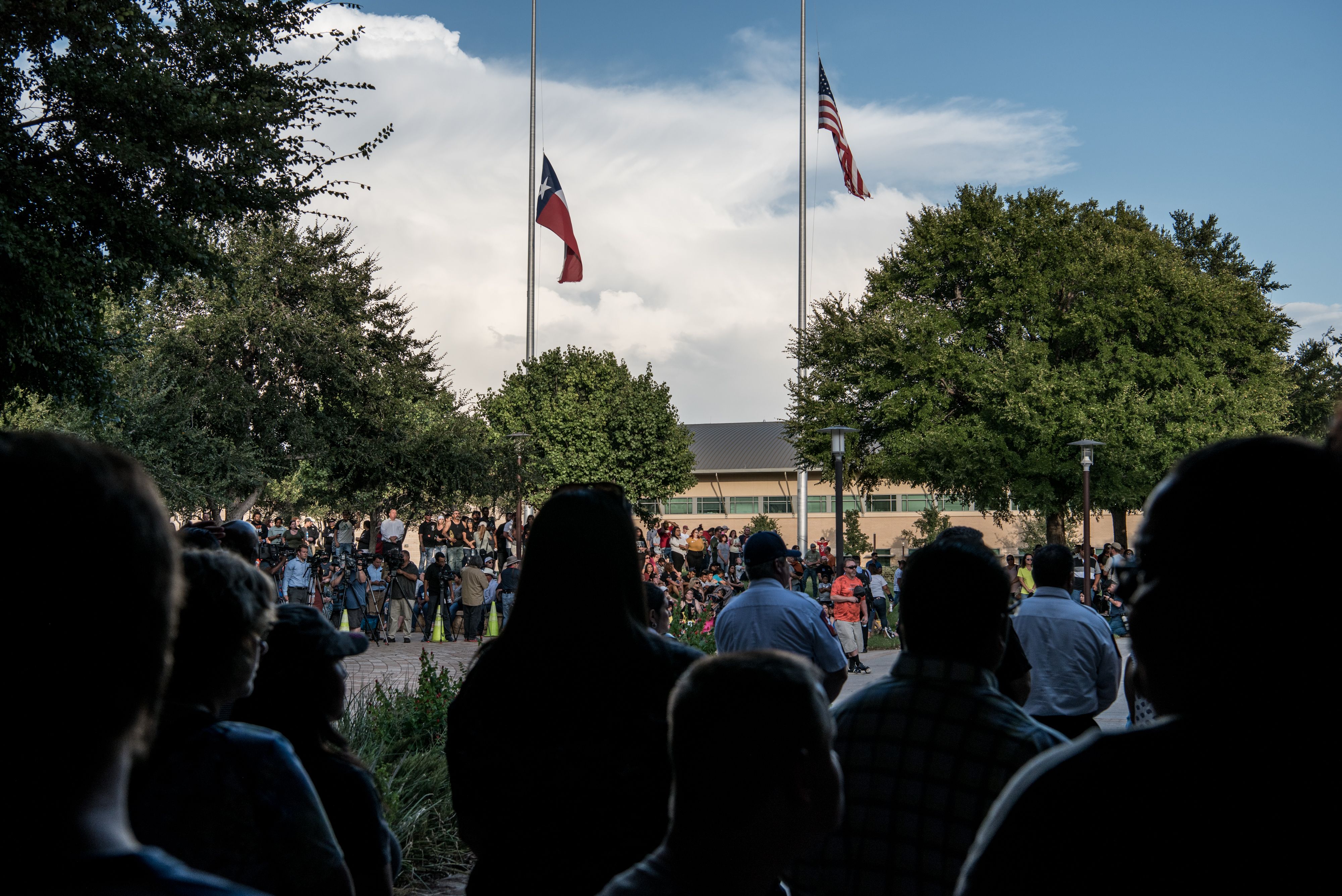 Flag fly at half mast over a prayer vigil at the University of Texas of the Permian Basin (UTPB)