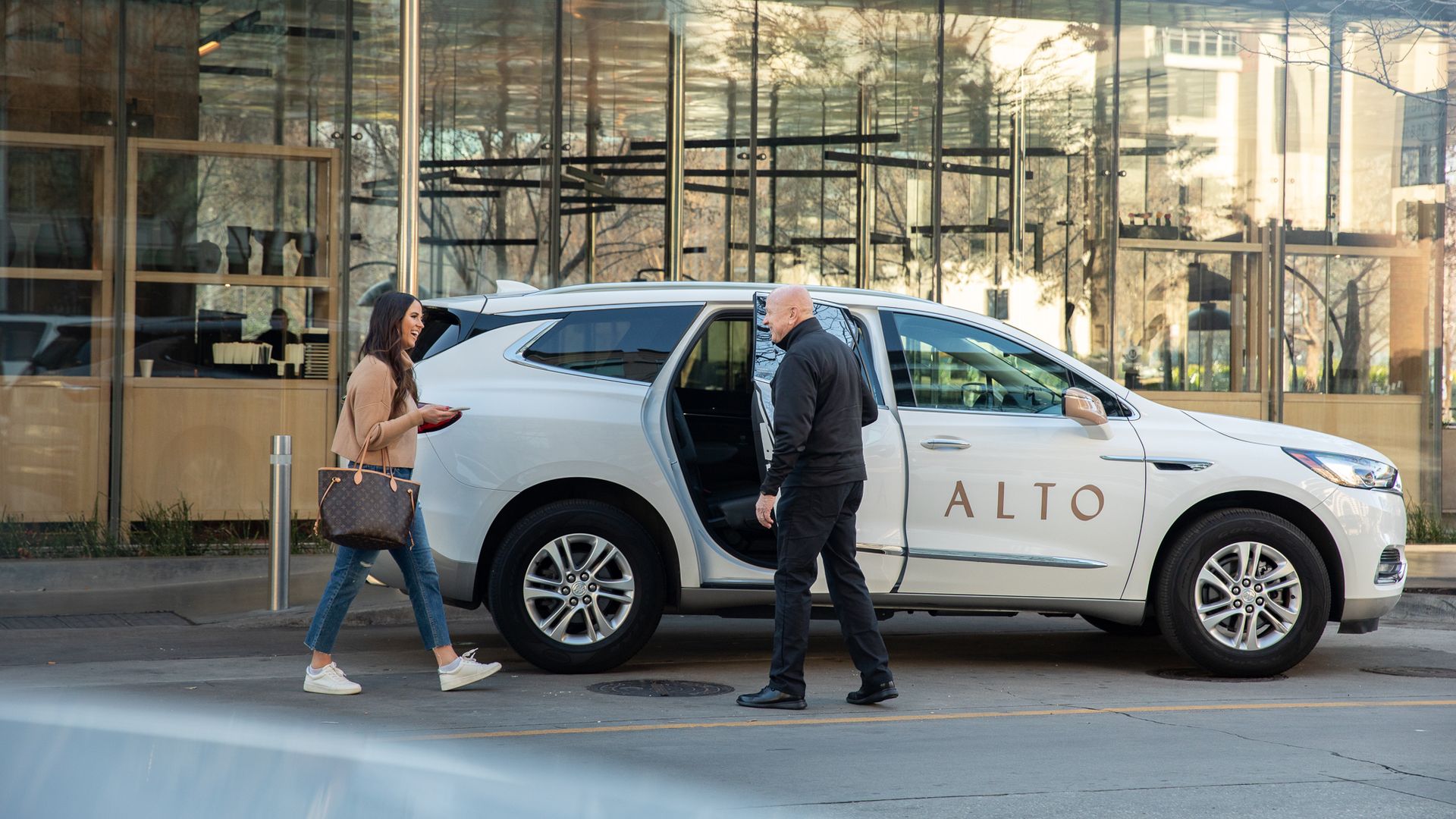 Driver holds door open to car that reads "Alto"
