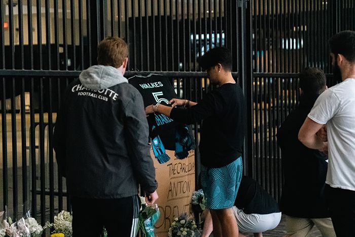 Fans lay a scarf at a vigil for Anton Walkes. 