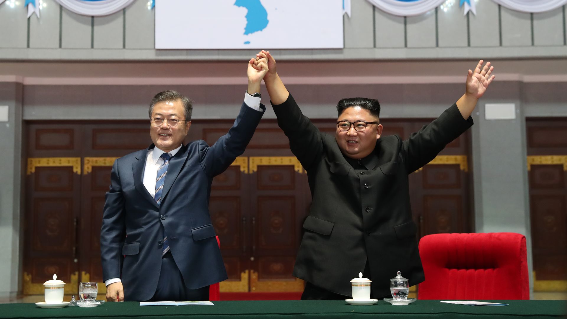 South Korean president and North Korean dictator raising hands together