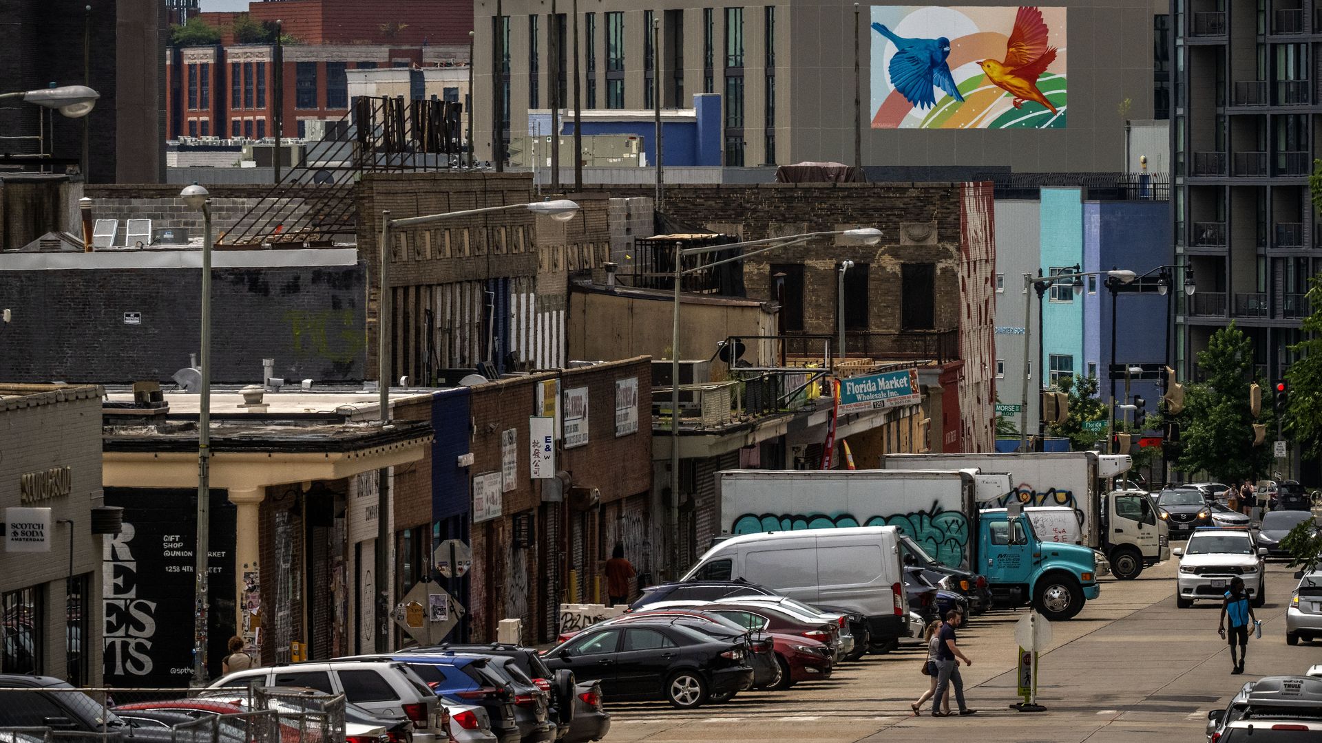  A view of the Union Market area, with a new mural on a building and people crossing the street.