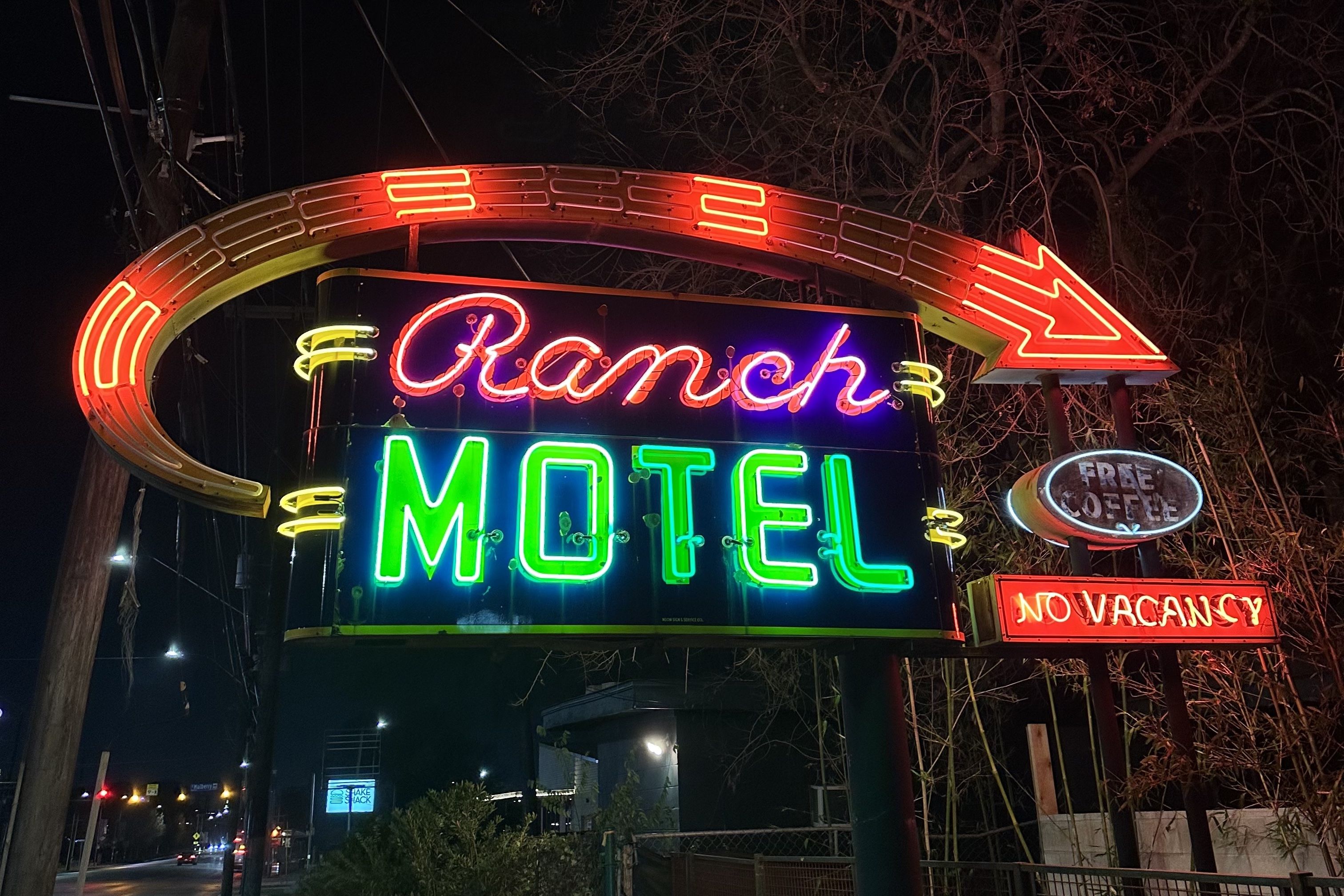A neon sign with an arrow and Ranch Motel lettering.