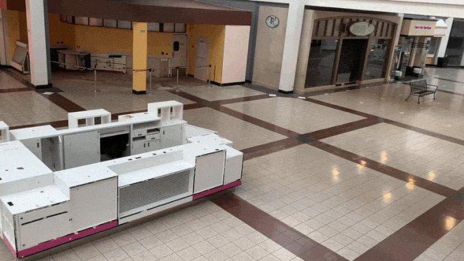 A GIF of a view from an escalator of an empty mall. 