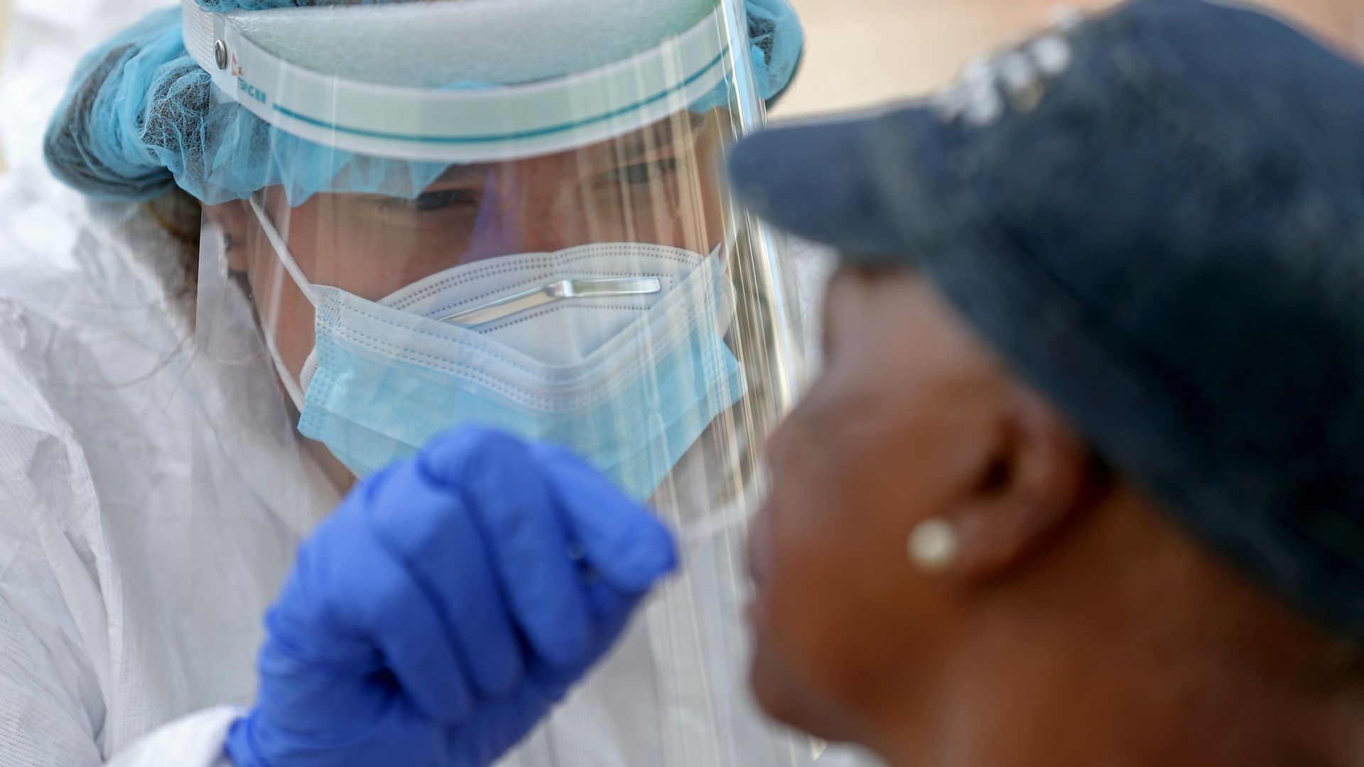 Krystal Rumenos an RN with the Whittier Street Health Center performs a COVID-19 test in the parking lot of Prince Hall Grand Lodge on August 3, 2020 in Roxbury, Massachusetts
