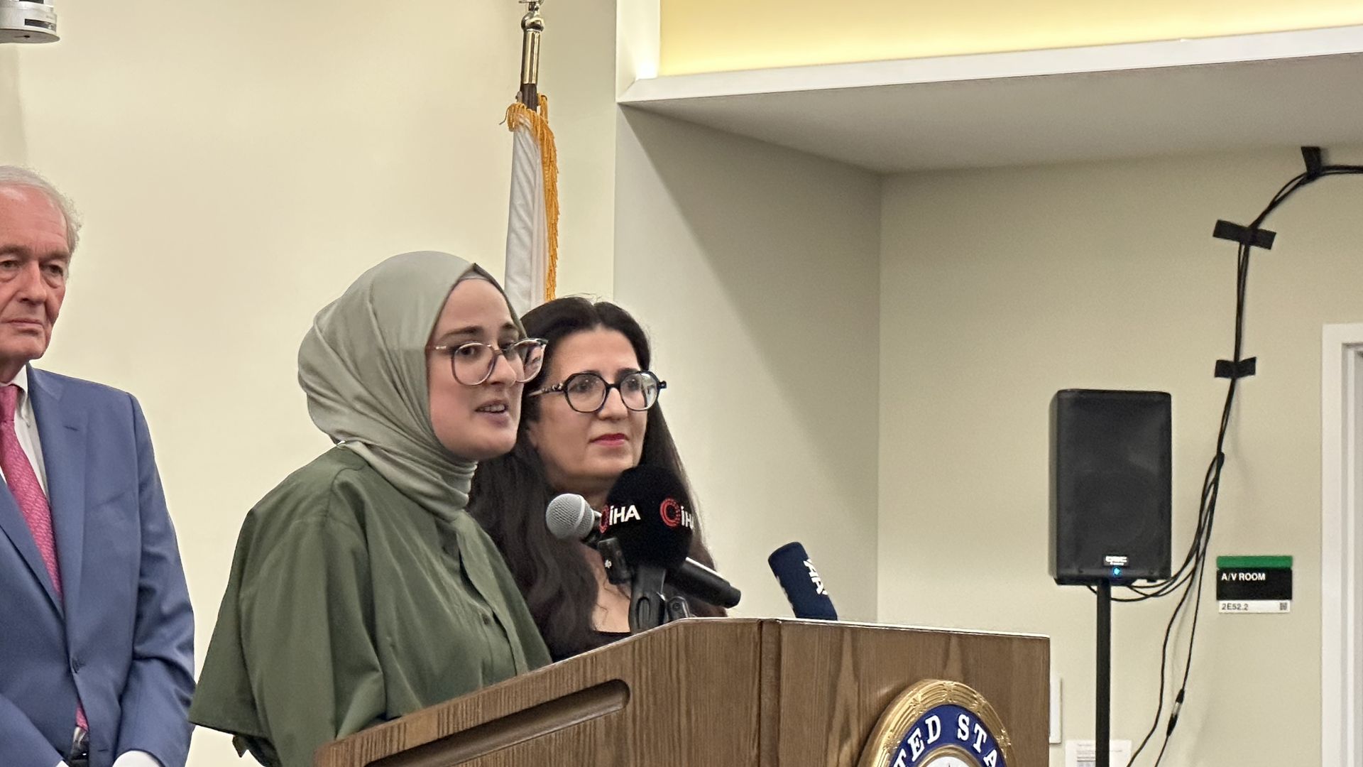 Rümeysa Öztürk speaks at a podium to reporters in the Logan Airport briefing room in East Boston a day after being released from ICE detention in Louisiana.