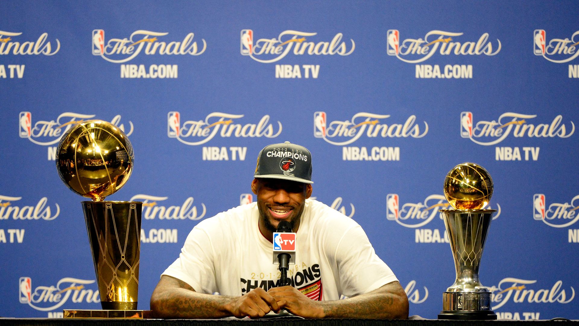 MIAMI, FL - JUNE 21: LeBron James #6 of the Miami Heat answers questions from the media next to the Larry O'Brien Finals Championship trophy and James' Bill Russell Finals MVP trophy during his post game press conference after they won 121-106 against the Oklahoma City Thunder in Game Five of the 20
