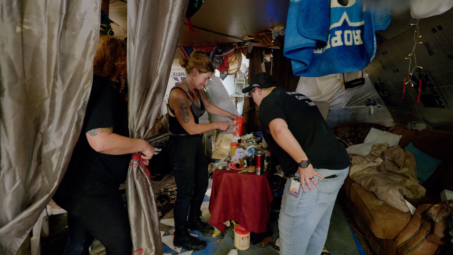 Photo of a volunteer talking to people in an encampment. 