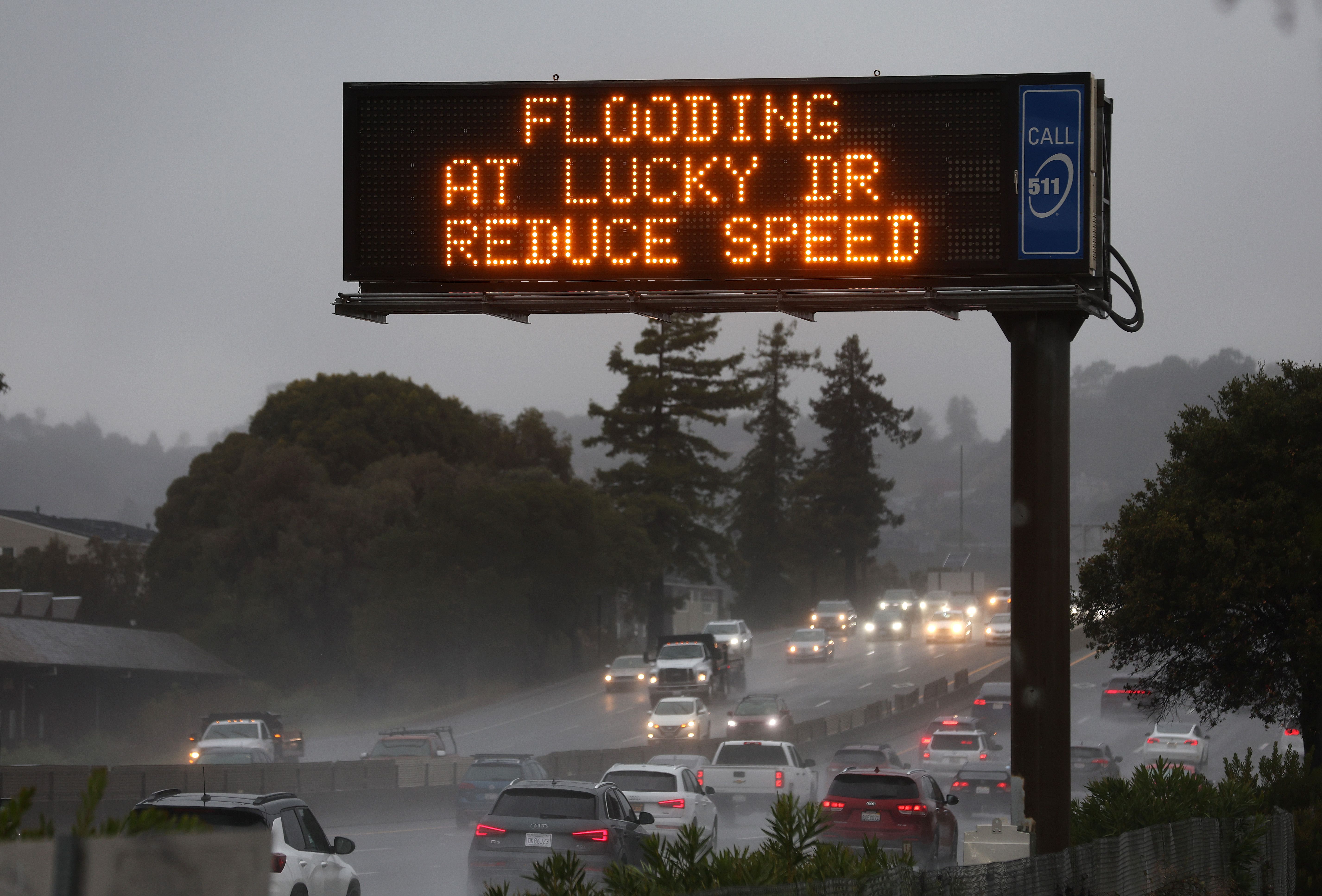 A sign warns drivers of flooding on Highway 101 on November 21, 2024, in Corte Madera, California. An atmospheric river is bringing heavy rains and wind to the San Francisco Bay Area for a second day and is expected to rain through the weekend.