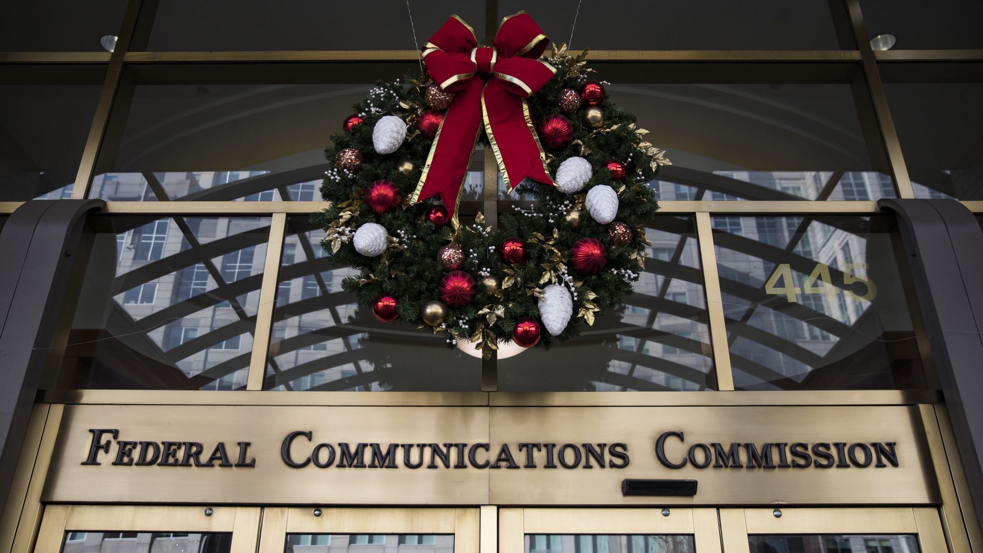 A photo of the entrance to the FCC's former headquarters, with a Christmas wreath hanging over the door