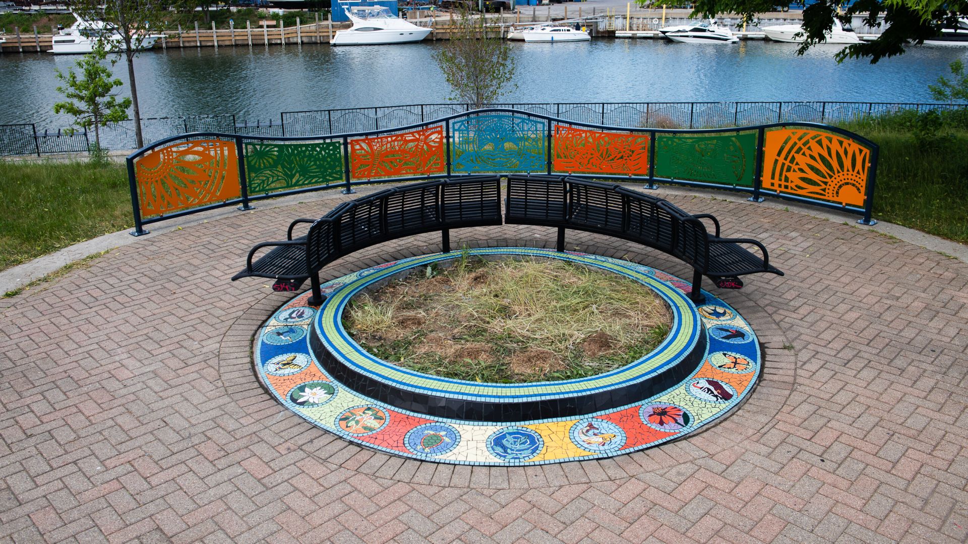 Photo of an art piece surrounded by grass along a river