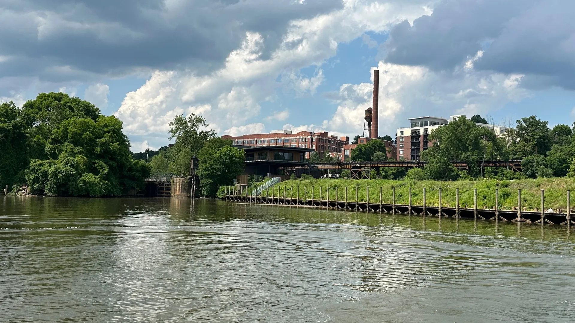 A view of the river, a dock and a building in the background