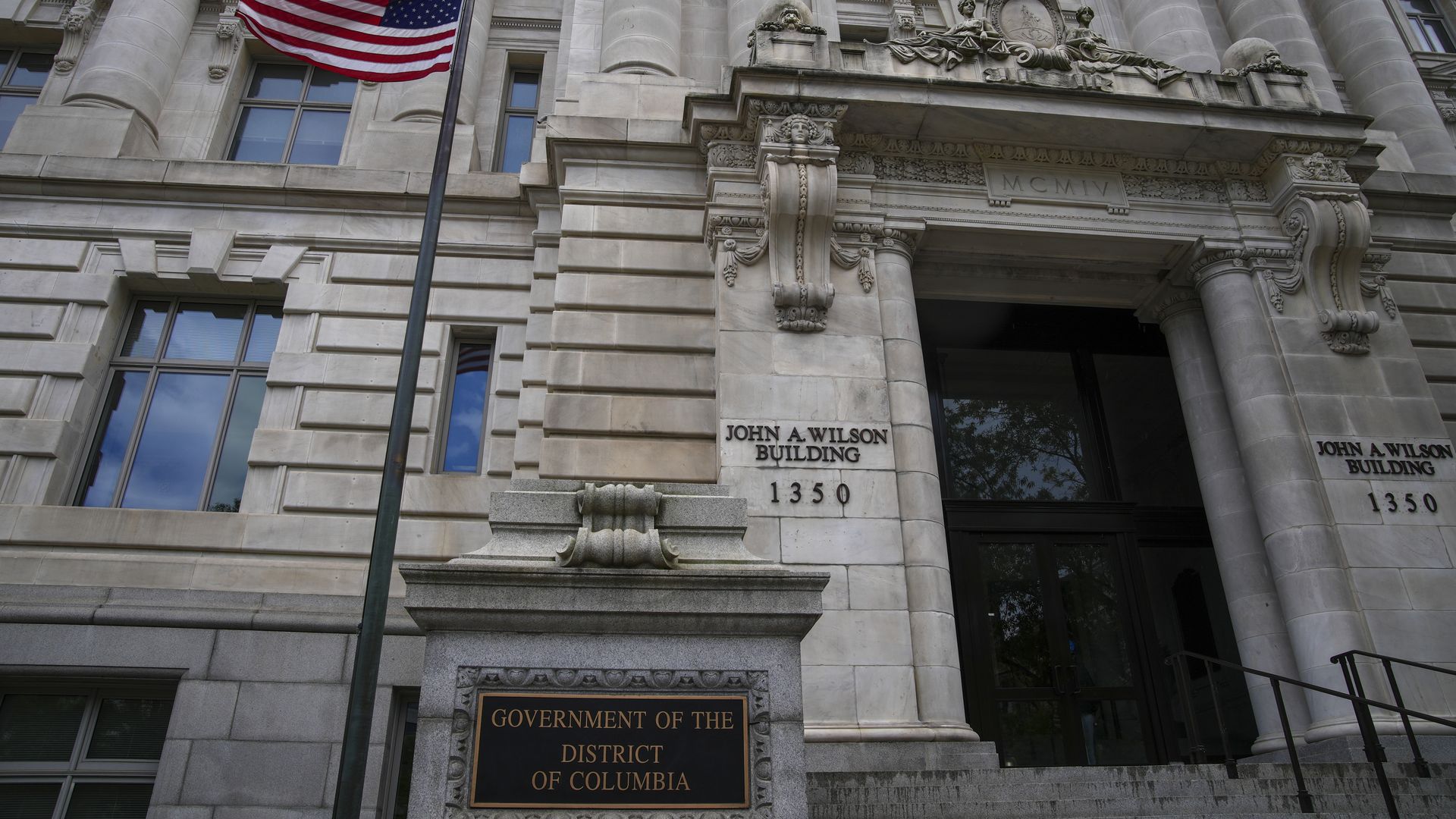 A photo showing the exterior of a grey stone building that reads "John A. Wilson Building."