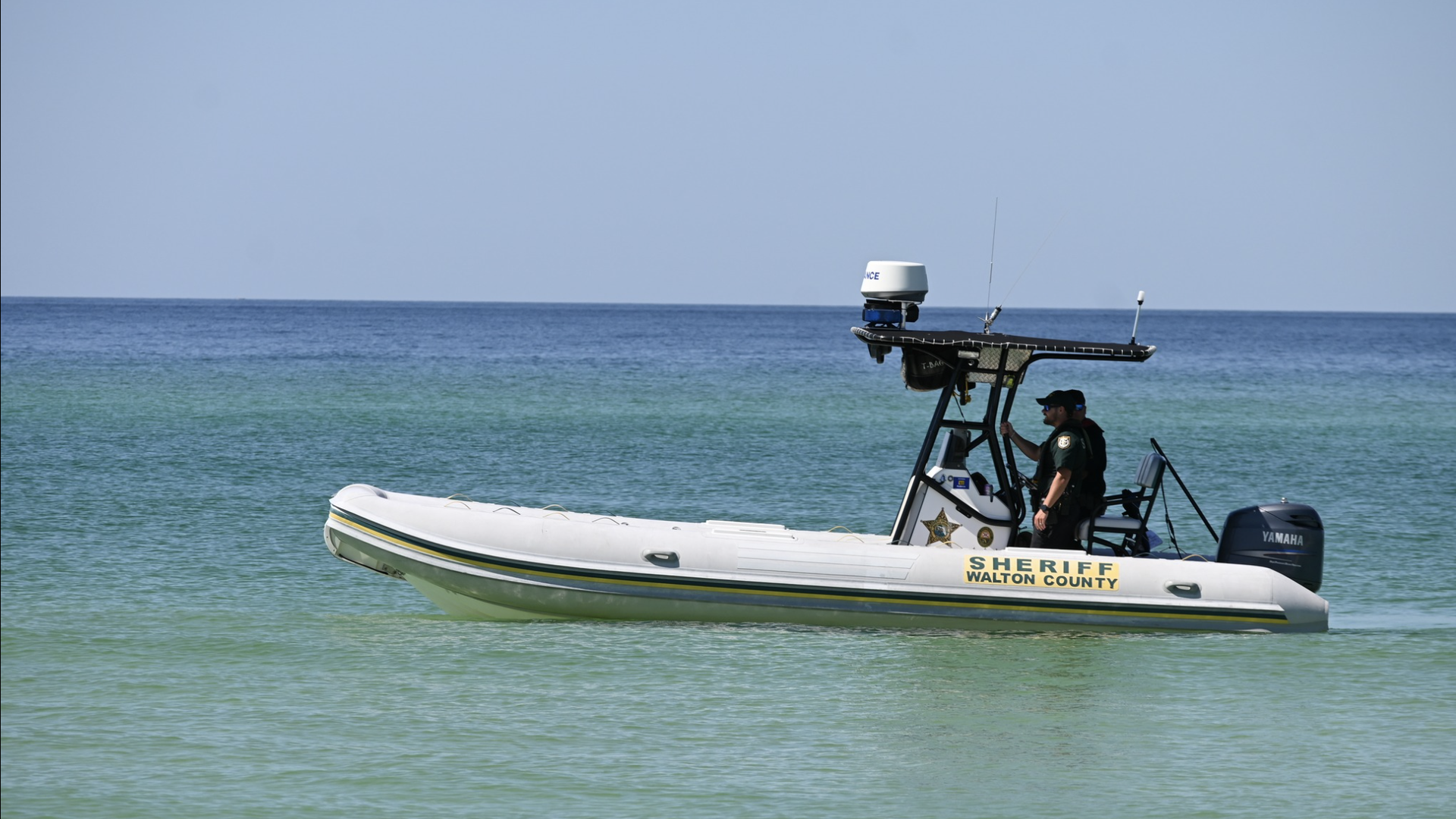 A picture of officers on a boat that says "Sheriff Walton County" riding along the ocean.