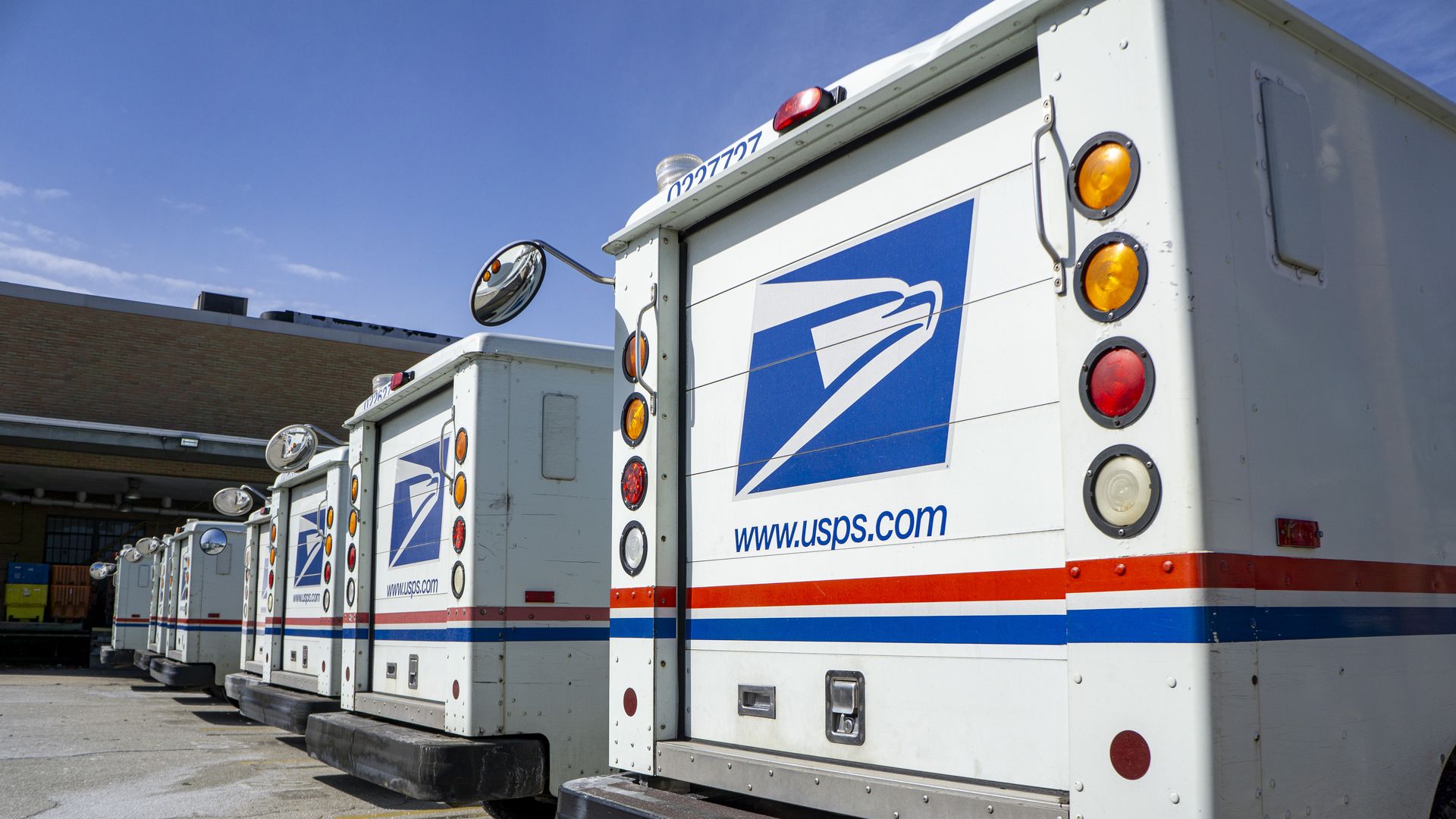 A row of USPS delivery trucks. 