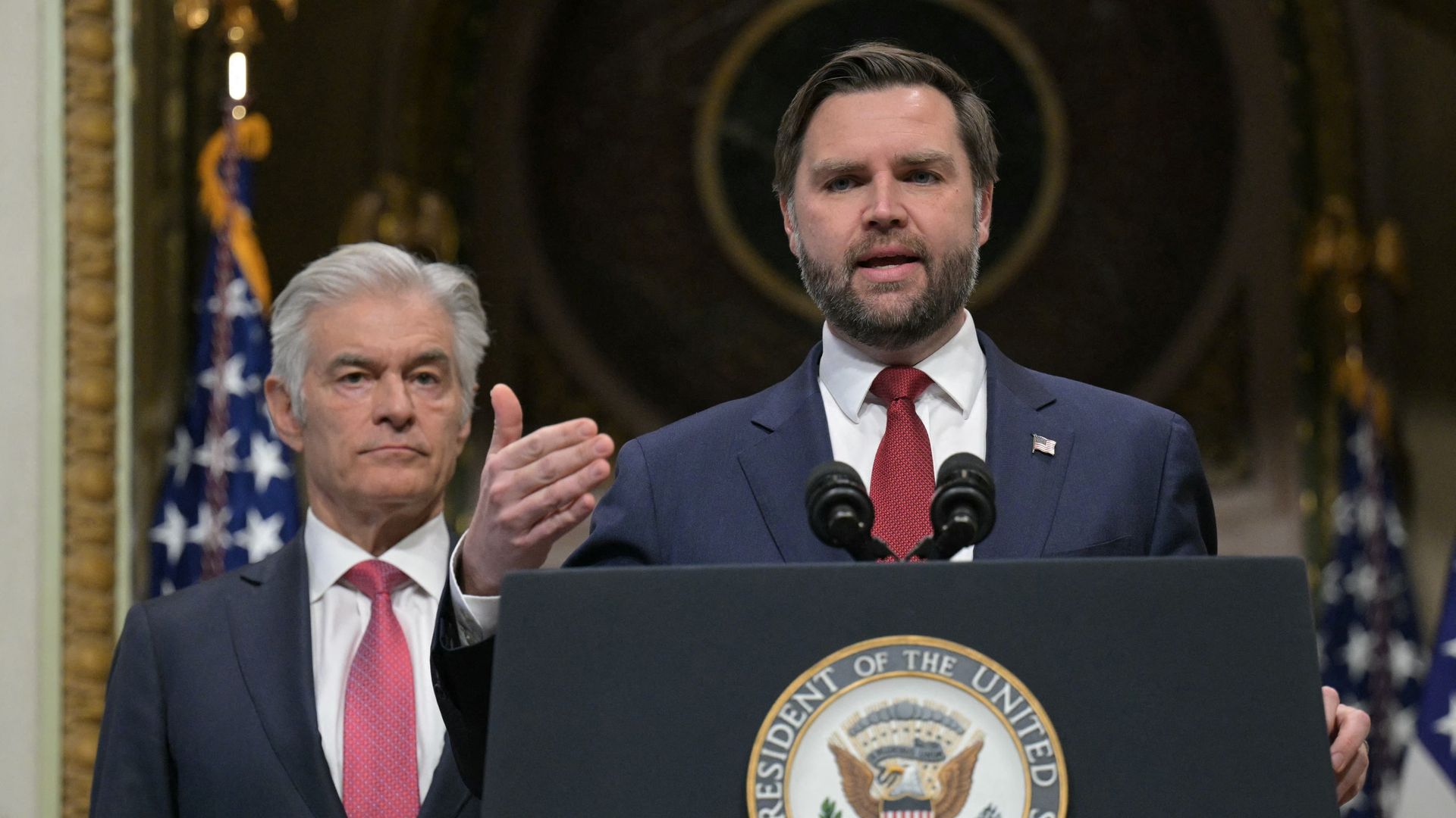 JD Vance and Mehmet Oz at a lecturn with the vice presidential seal on it.
