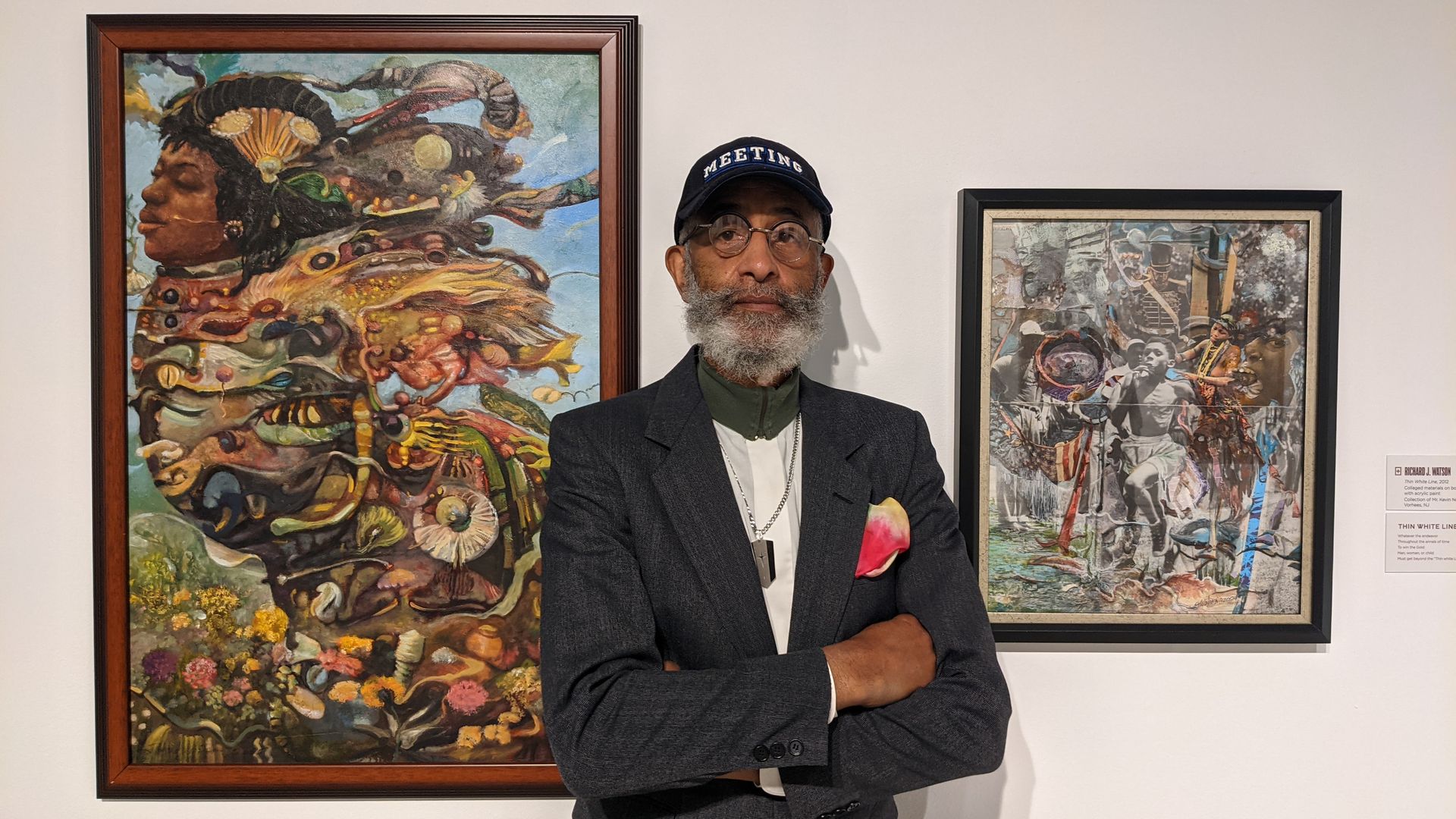Artist Richard Watson standing in front of two of his paintings on display at the African American Museum in Philadelphia.