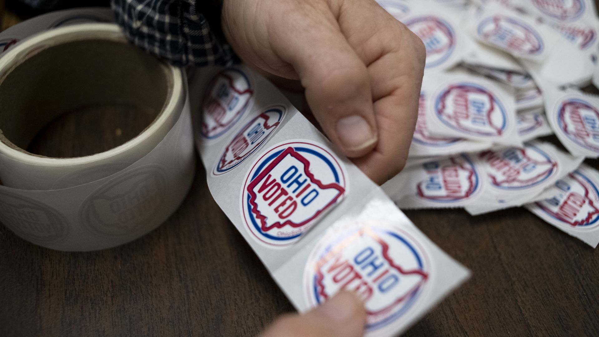 A person pulls off "Ohio Voted" stickers at a polling place.