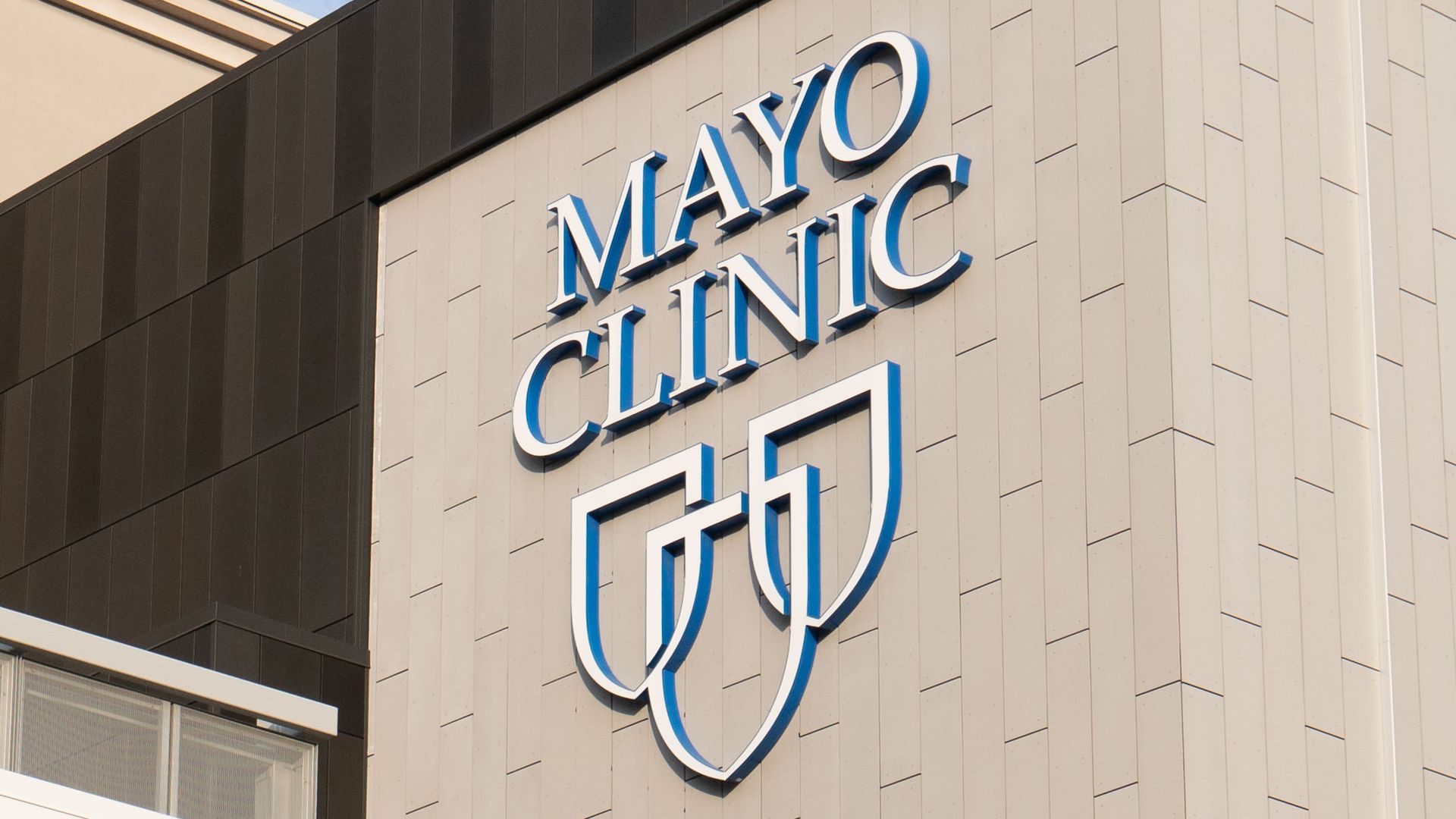 The blue and white Mayo Clinic logo on a beige building.