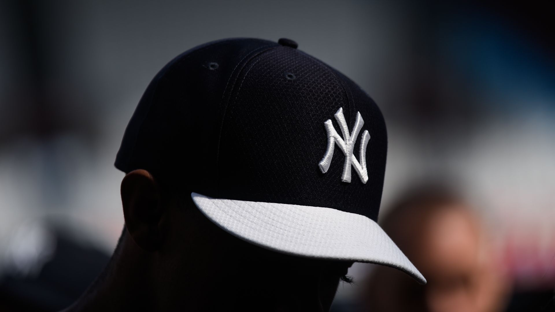 A New York Yankees player wears a batting practice hat.