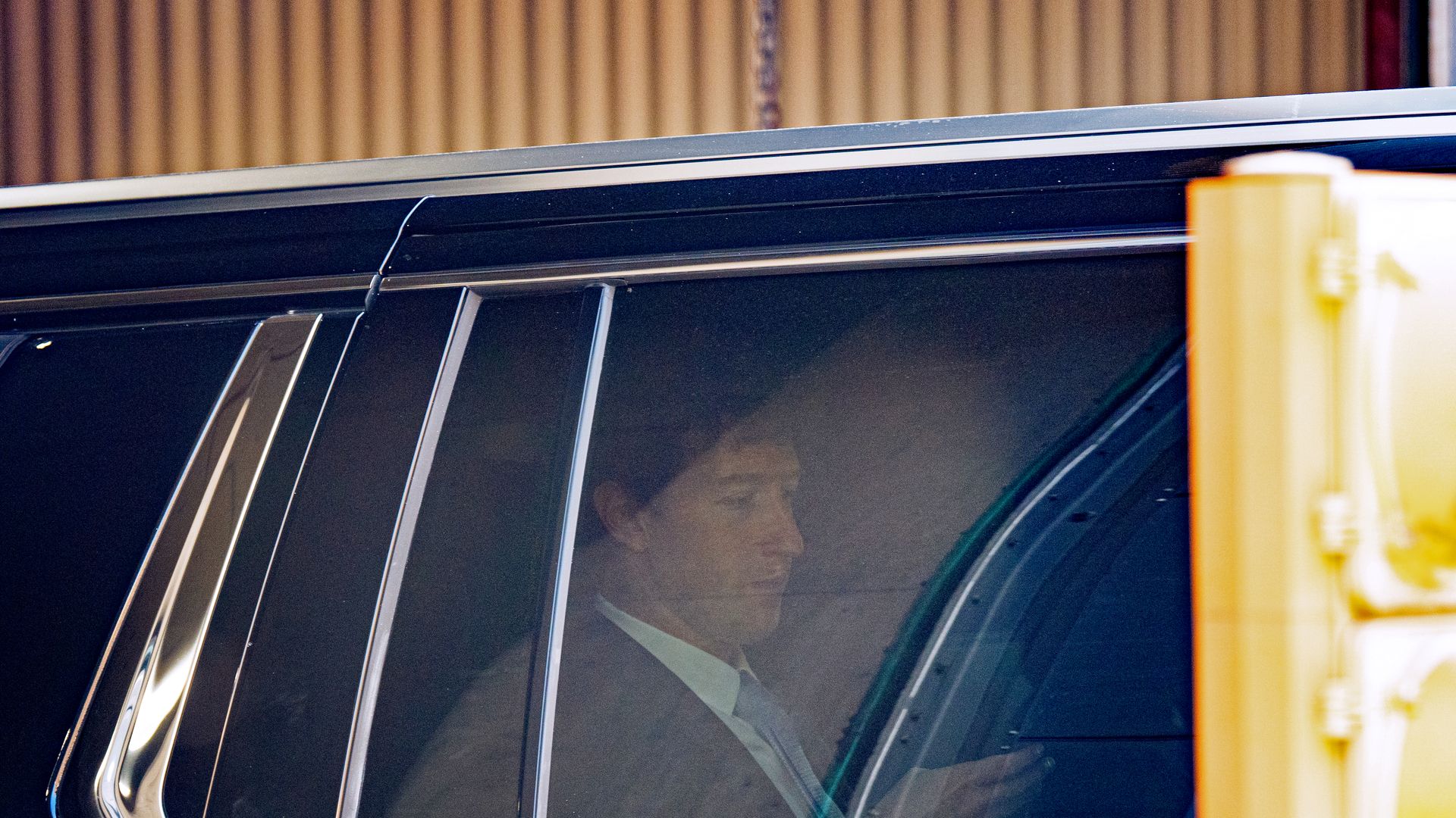 A person in a car looks at what appears to be a cell phone