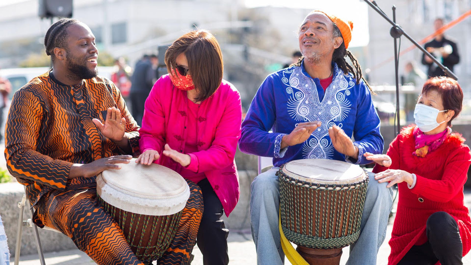 Photo of two West African drummers playing their instruments with two Chinese seniors
