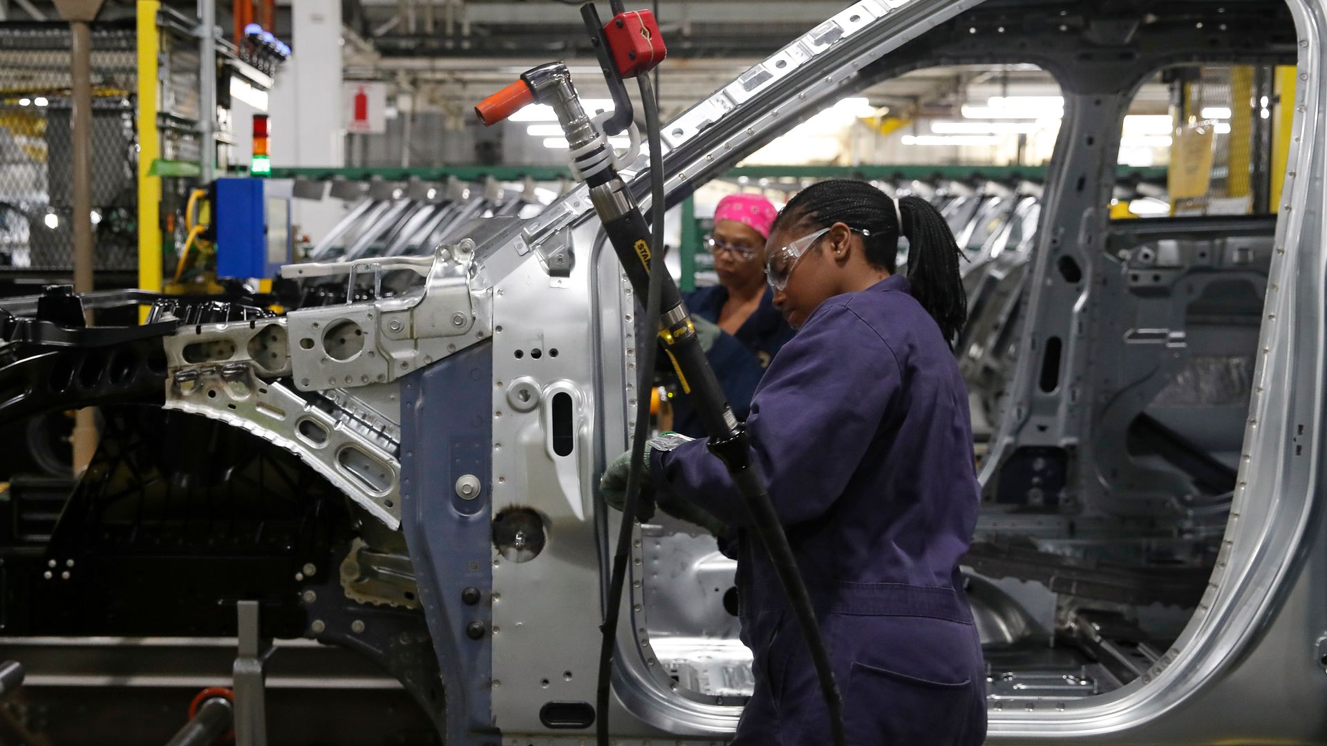 Workers assemble cars at the newly renovated Ford's Assembly Plant in Chicago,