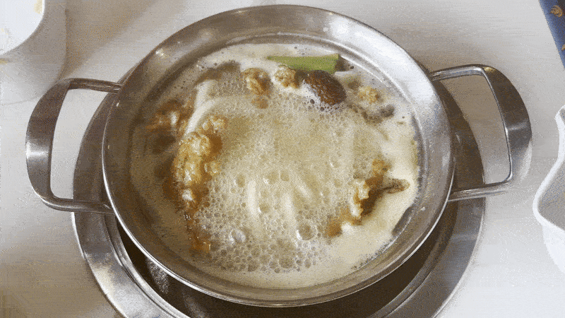 Image shows a pot boiling with noodles.