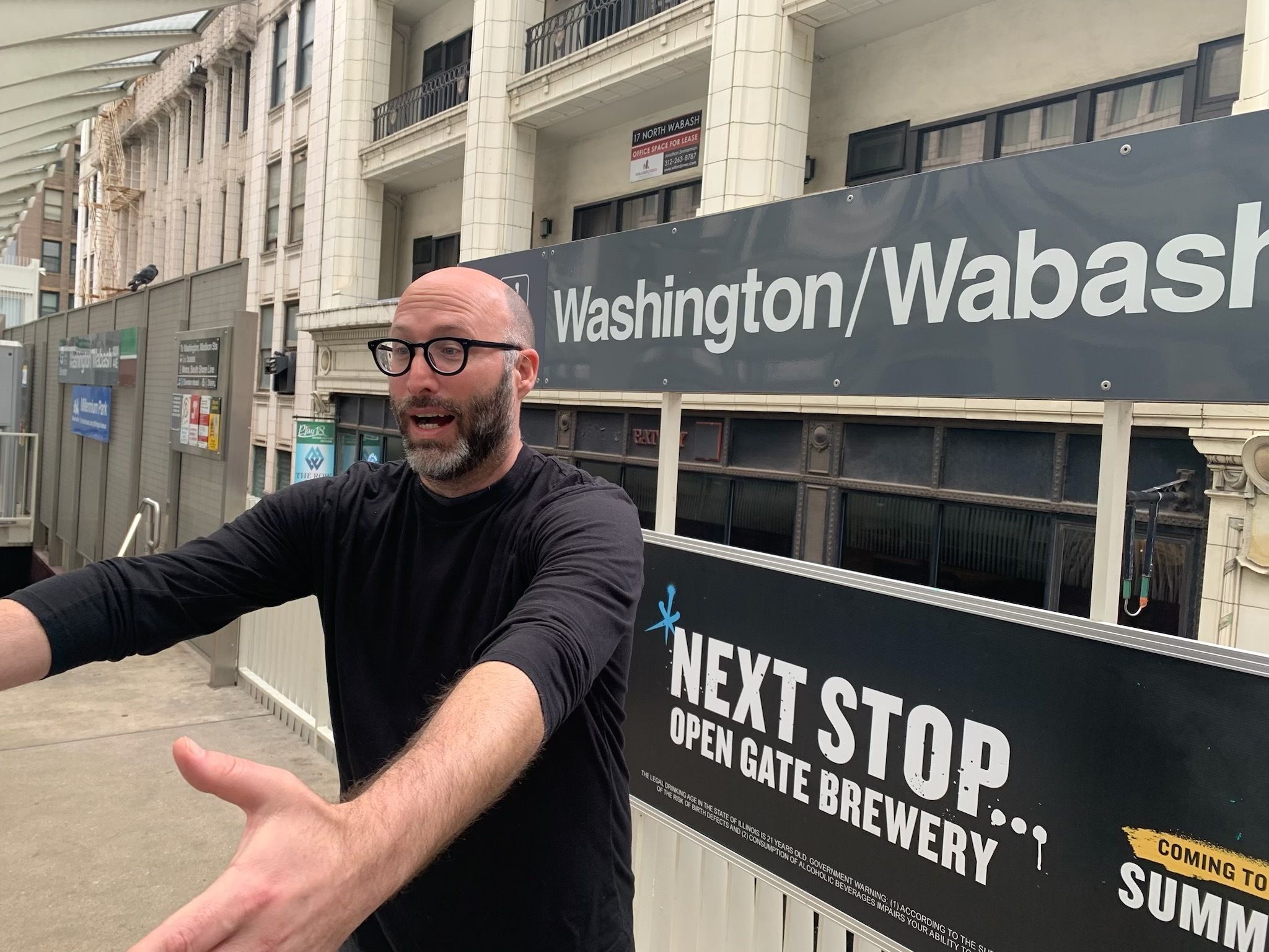 Photo of a man holding his arms out to help someone at a train station