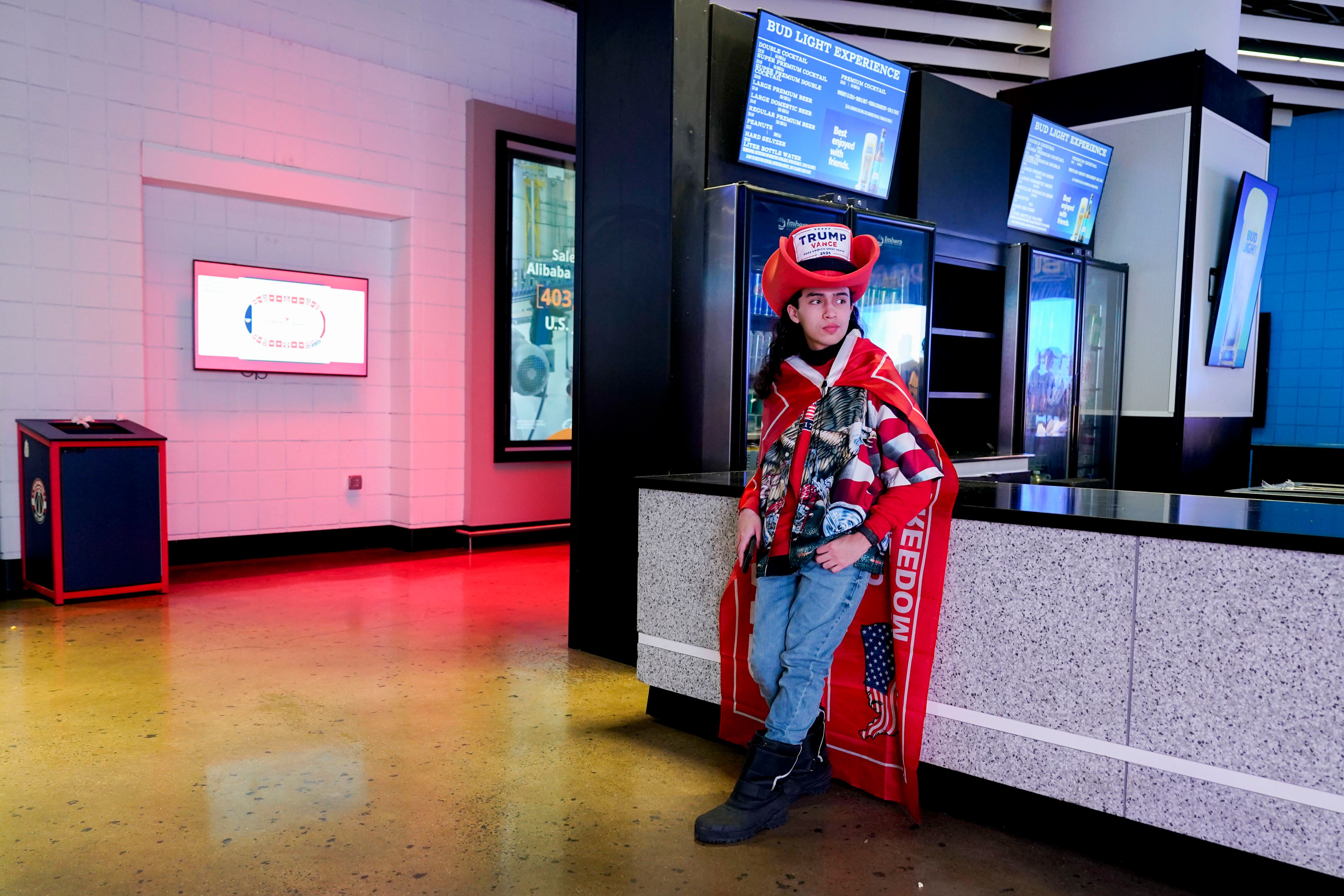 A photo of a President Trump supporter leaning against a counter at Capital One Arena.