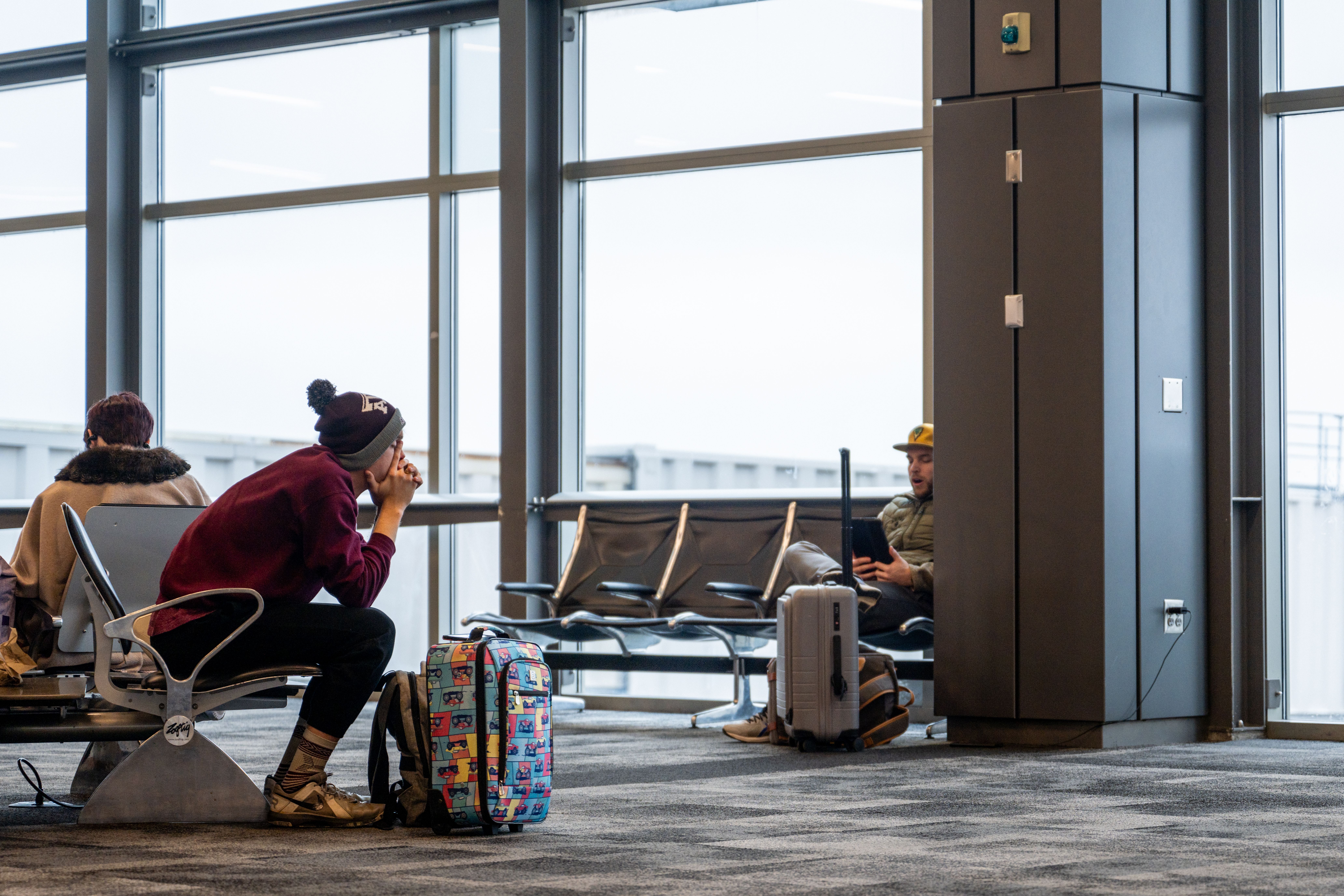A person sits at a gate at the airport.