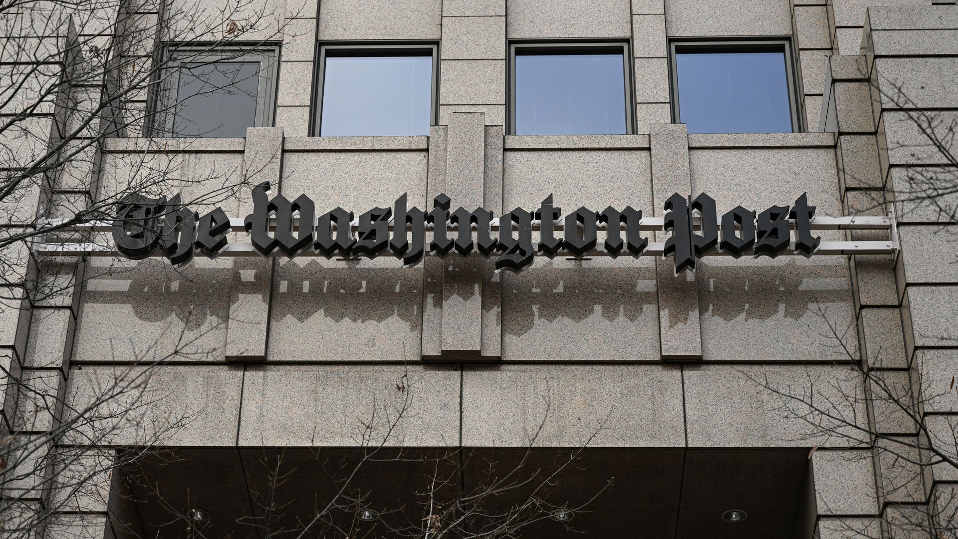 A sign reading "The Washington Post" attached to the outside of an office building.