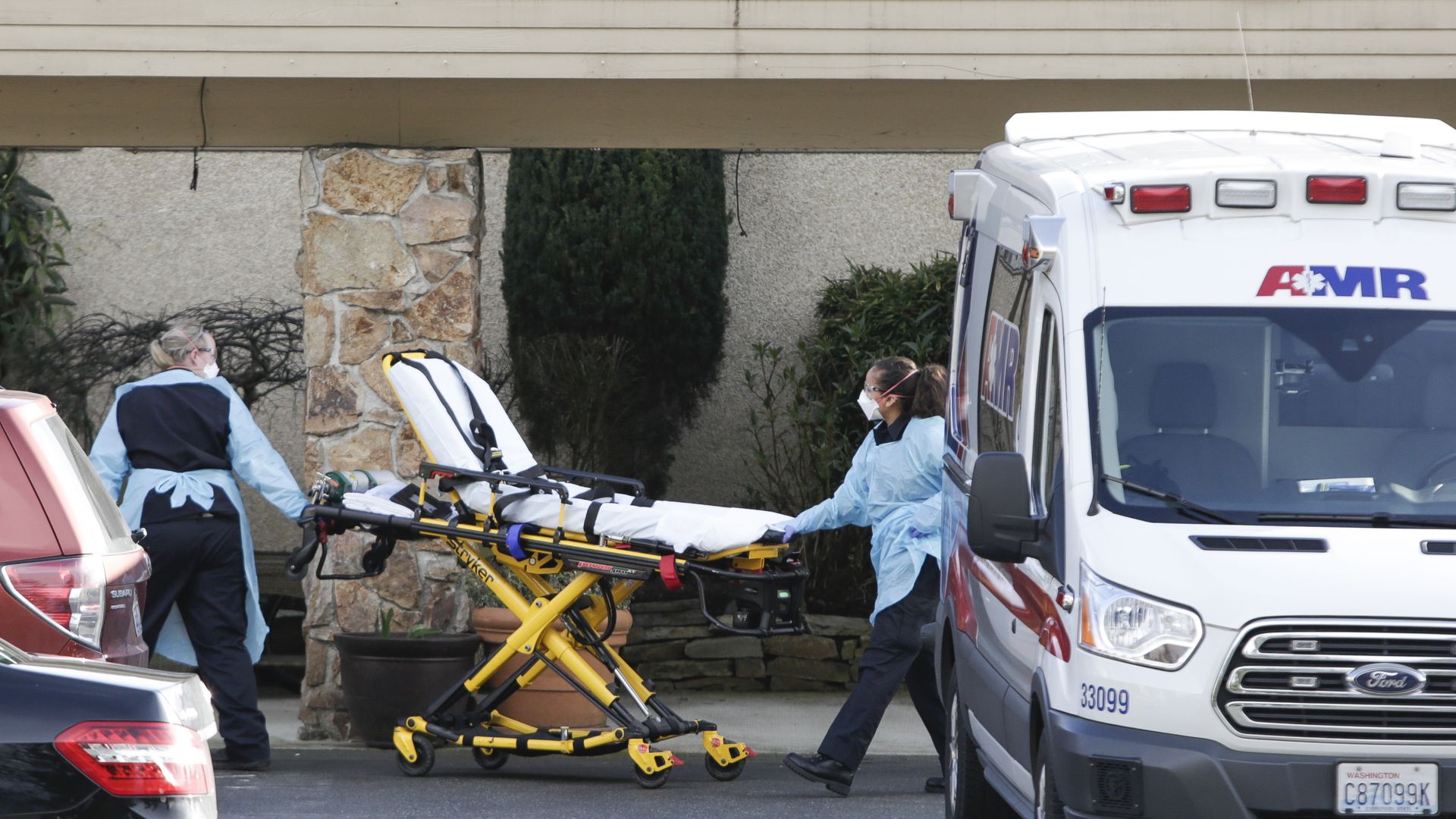 A stretcher is moved from an AMR ambulance to the Life Care Center of Kirkland