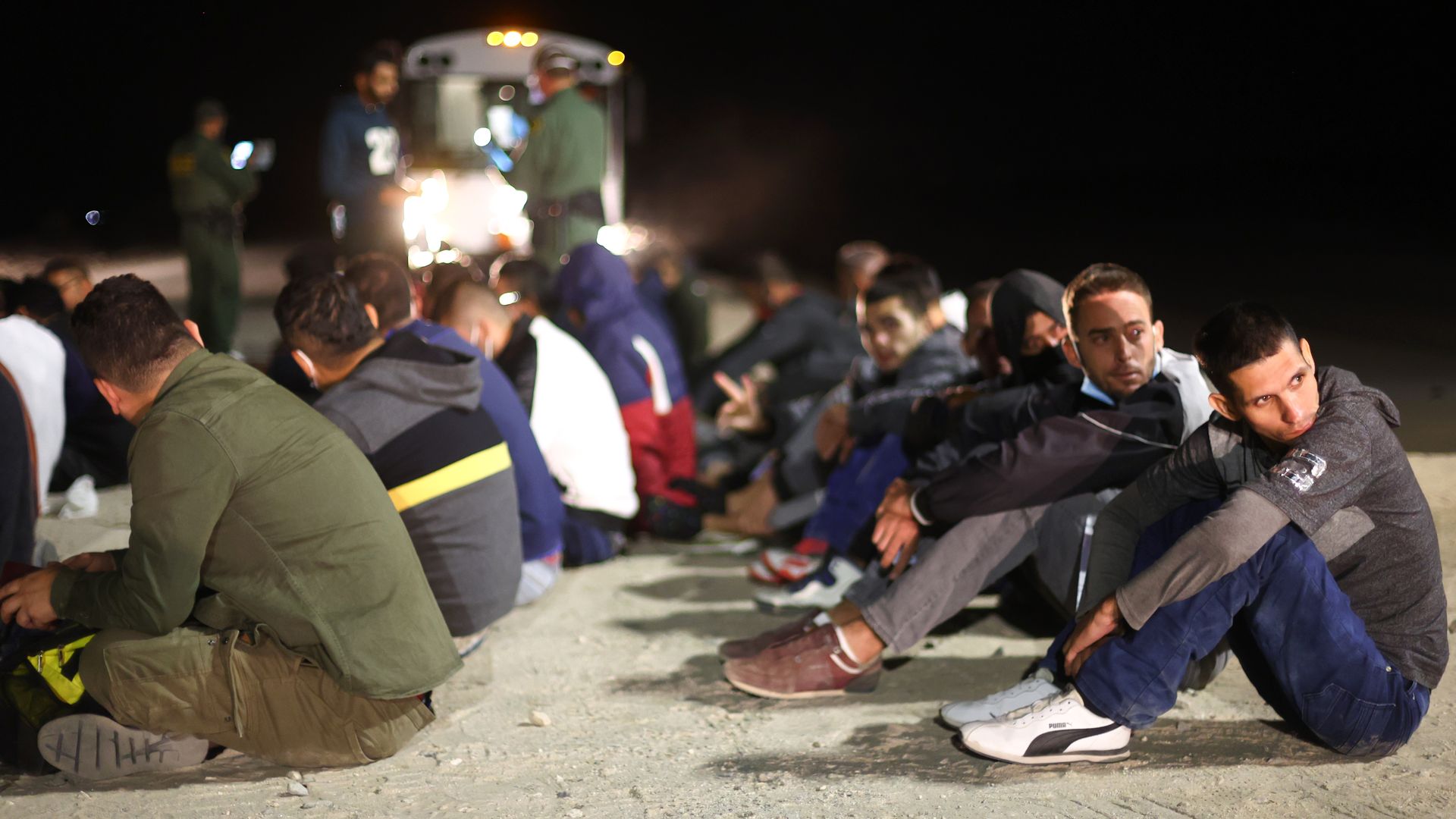 Immigrants wait to board a U.S. Border Patrol bus to be taken for processing after crossing the border from Mexico