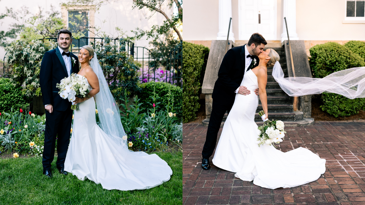 Wedding couple in black tuxedo and white gown; bride holds white bouquet with veil flowing, standing in garden and kissing on stone patio steps.