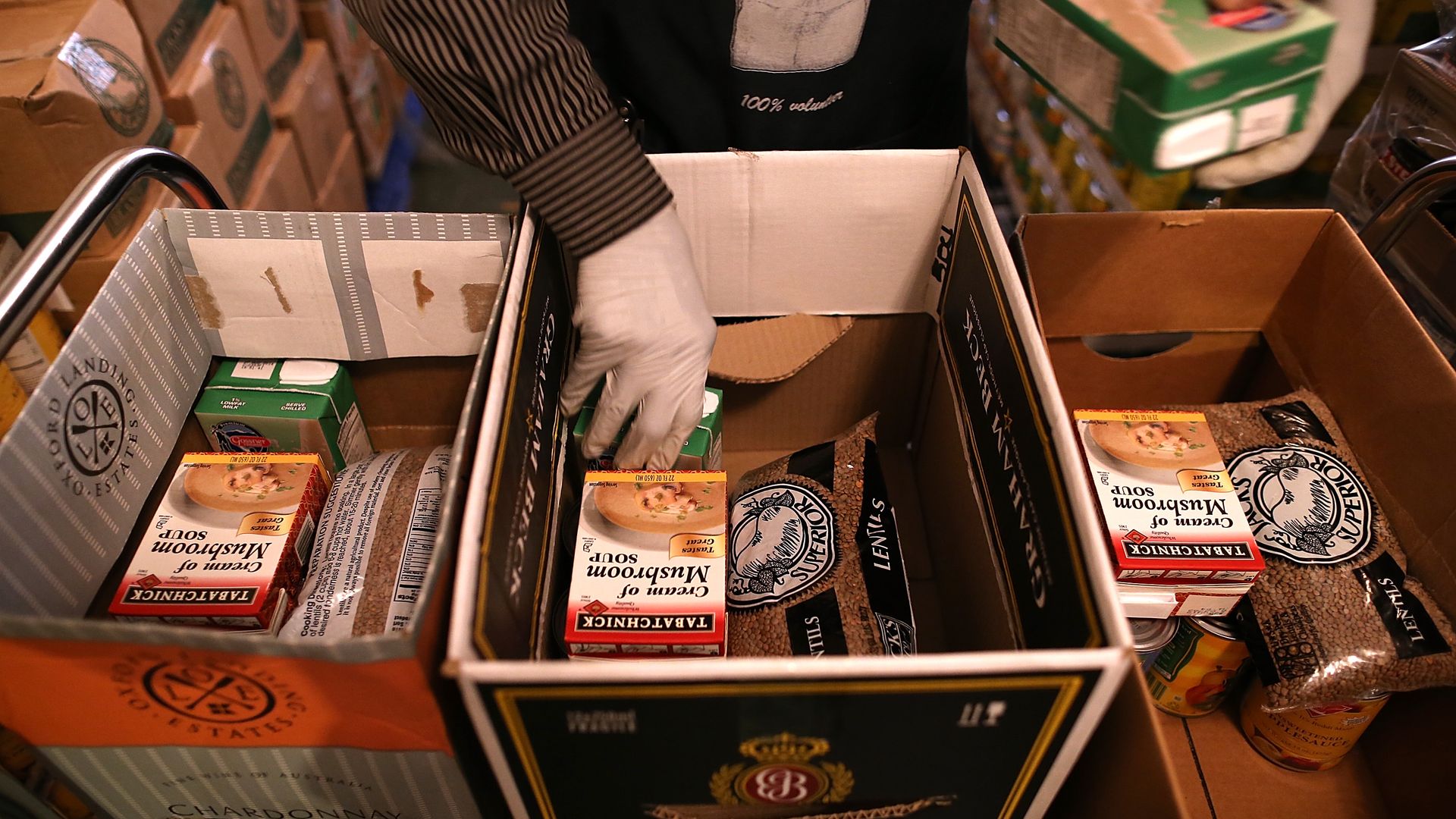 A volunteer packs boxes with food to be handed out to needy people.