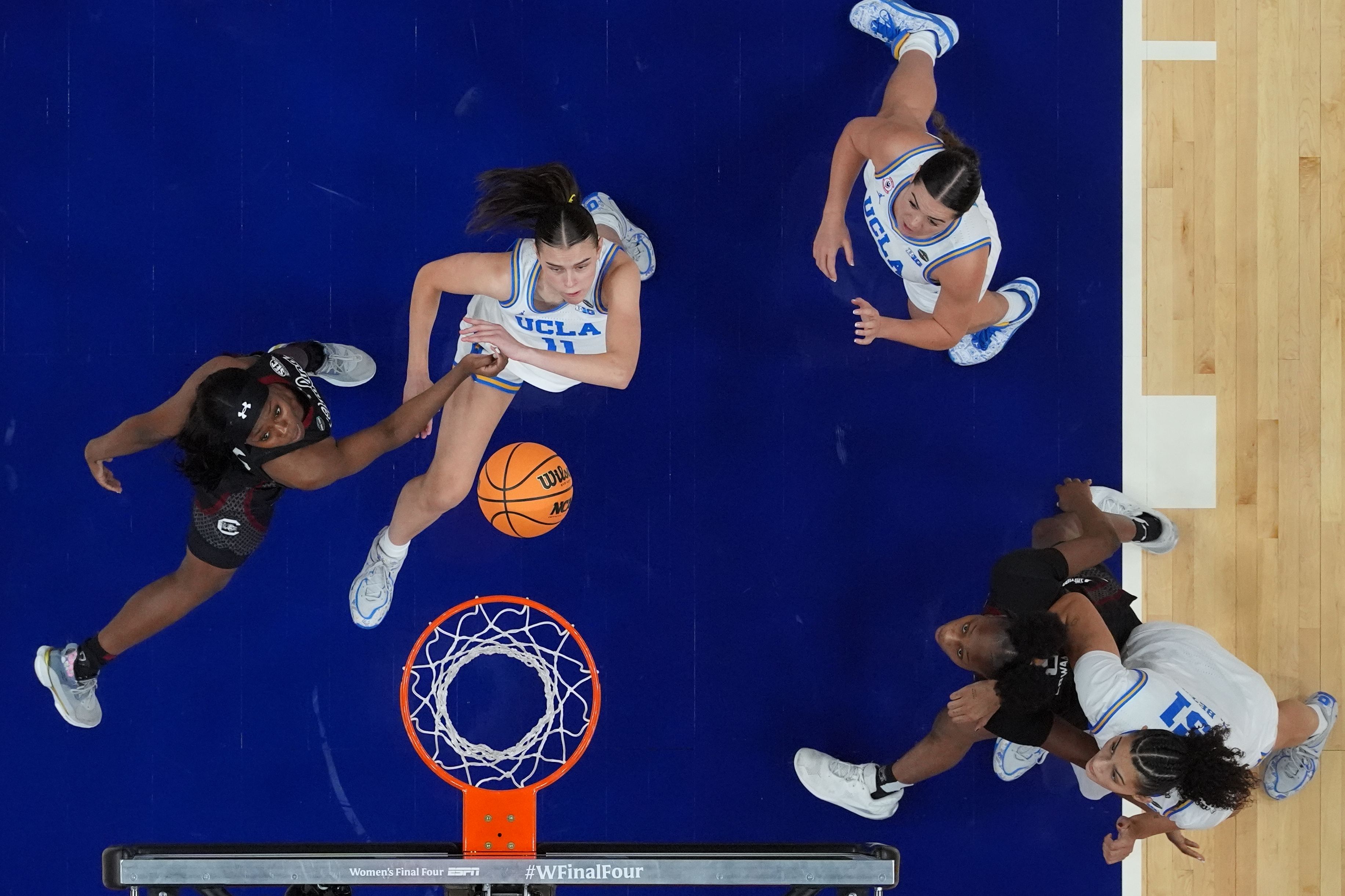 UCLA guard Gabriela Jaquez, second from left, shoots over South Carolina guard Raven Johnson, left, during the second half of the women's National Championship Final Four NCAA college basketball tournament game, Sunday, April 5, 2026, in Phoenix. (AP Photo/Ross D. Franklin)