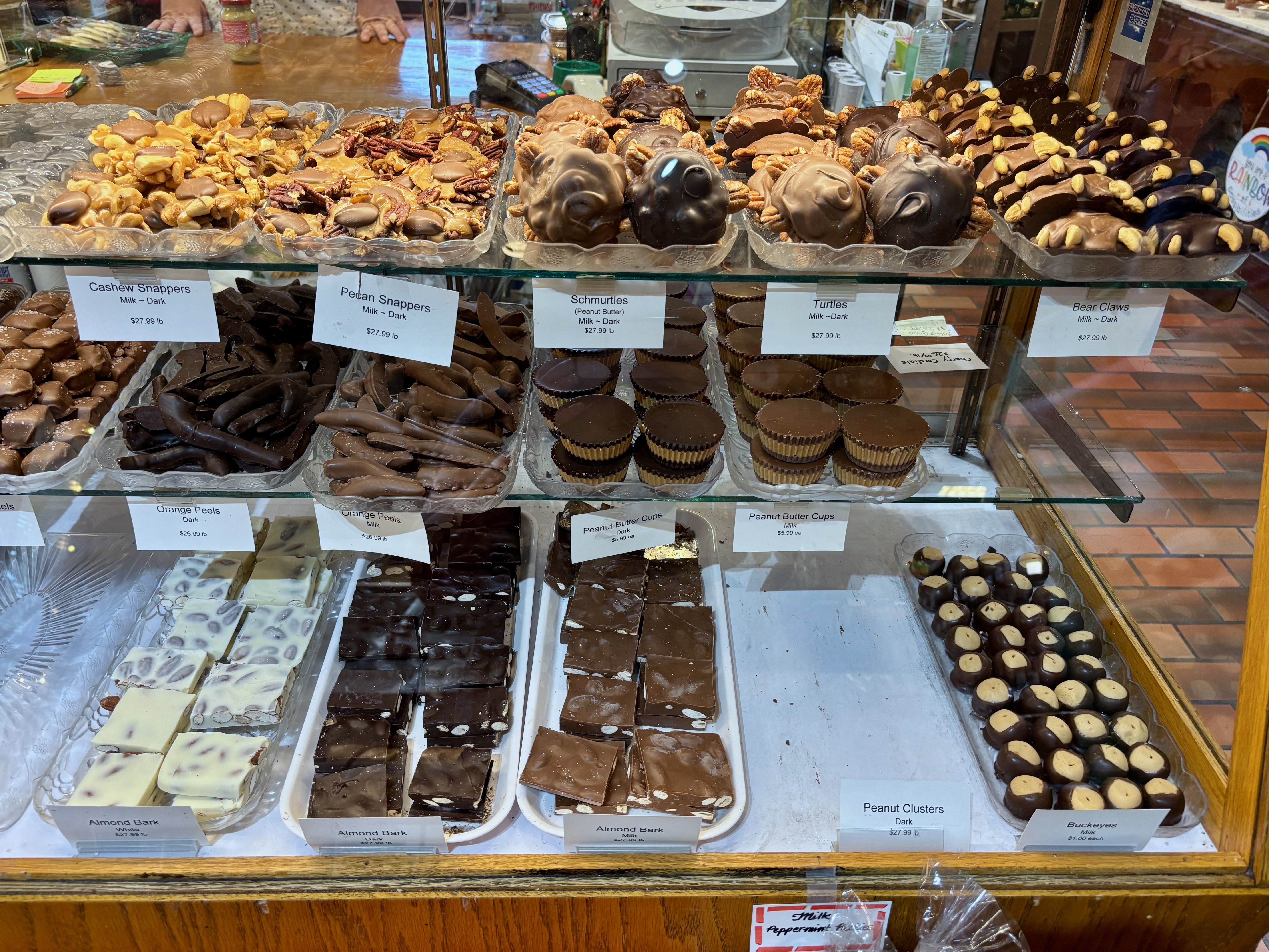 A display case full of chocolates at the Fudge Haus, including peanut butter cups, buckeyes, almond bark and pecan clusters