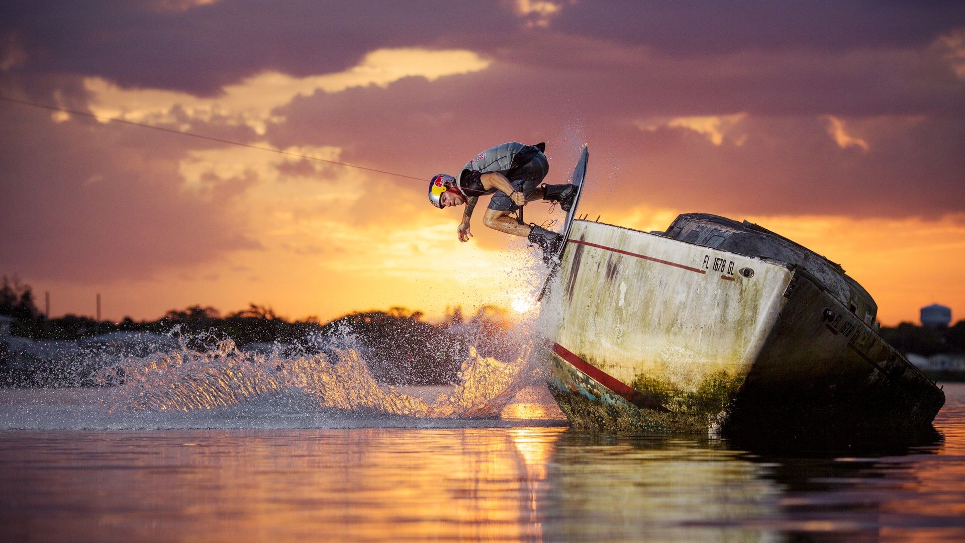 Massi Piffa wakeboards on abandoned boat at sunset in Sebastian, Florida.