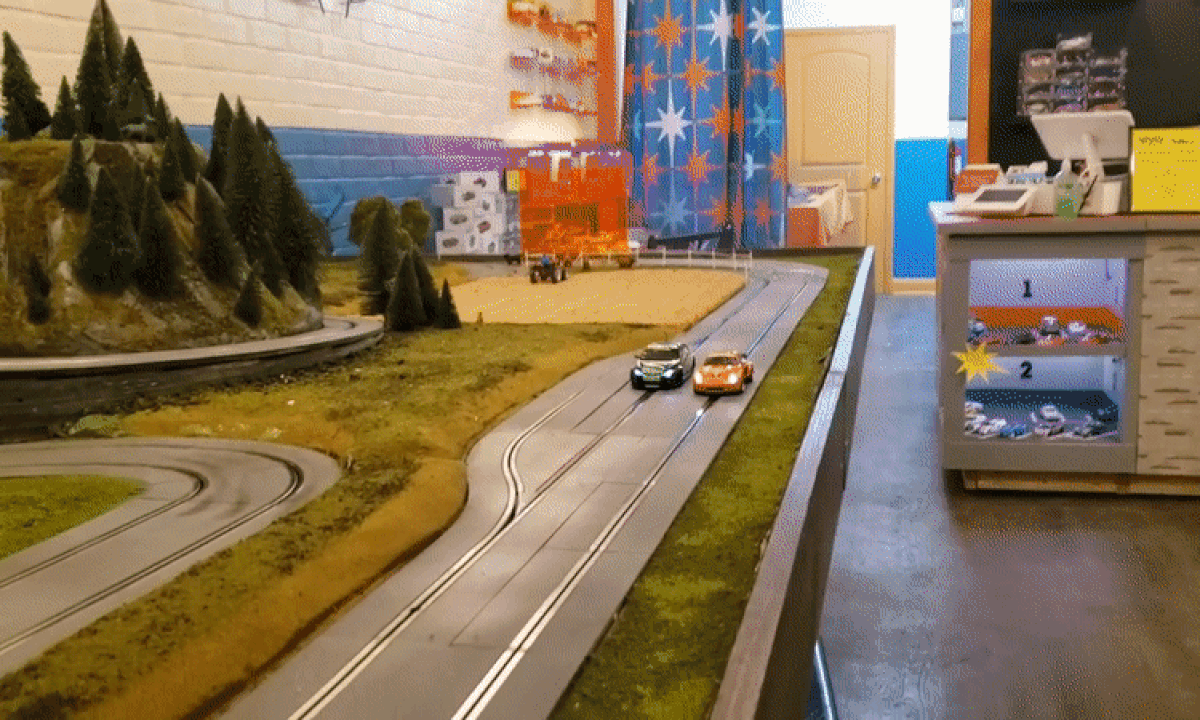 GIF of a slot race track and two cars speeding by. 