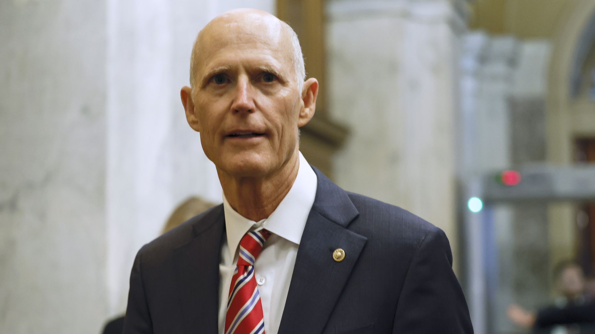 Rick Scott talks with reporters at the Capitol