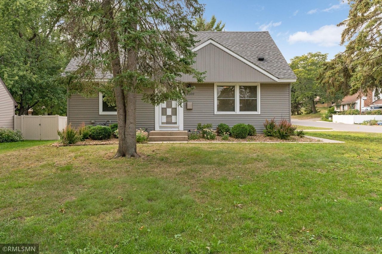 exterior of grey home with tree in front
