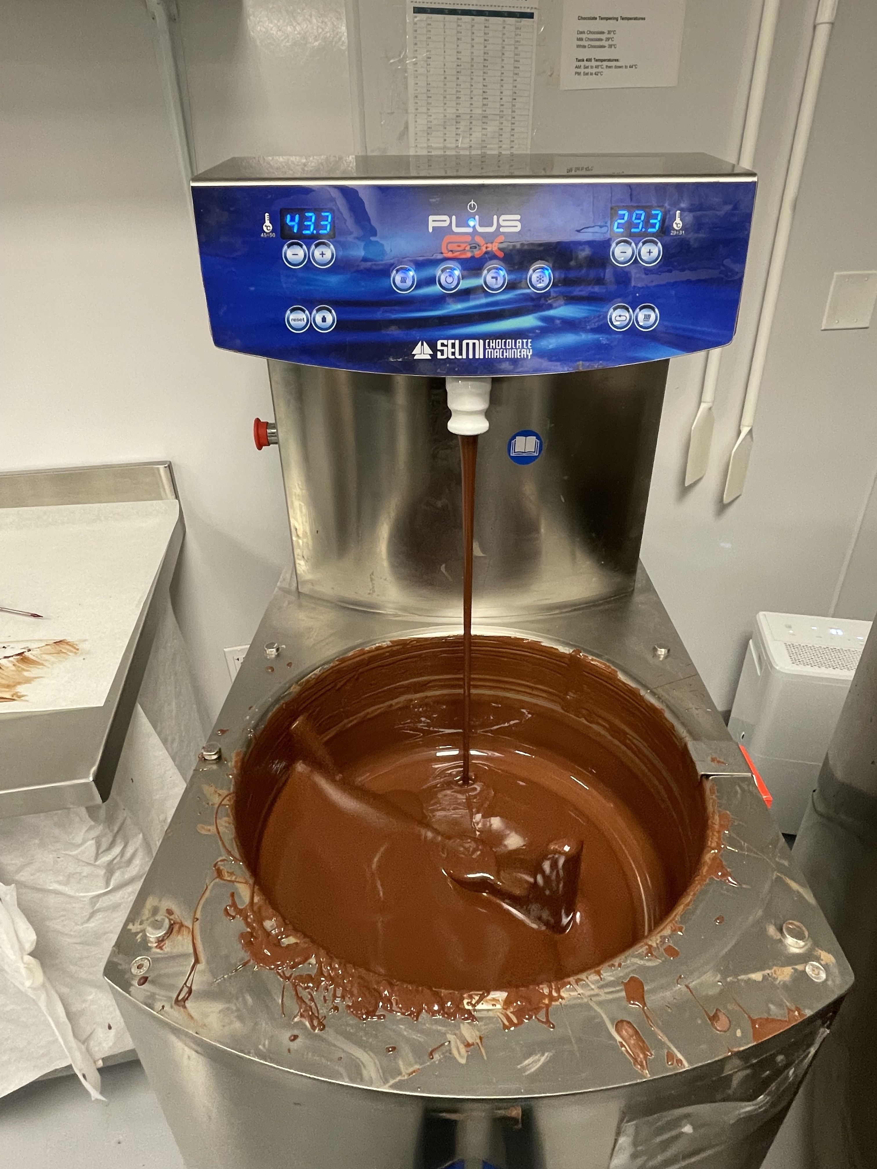 Chocolate drips down a vat as it swirls.