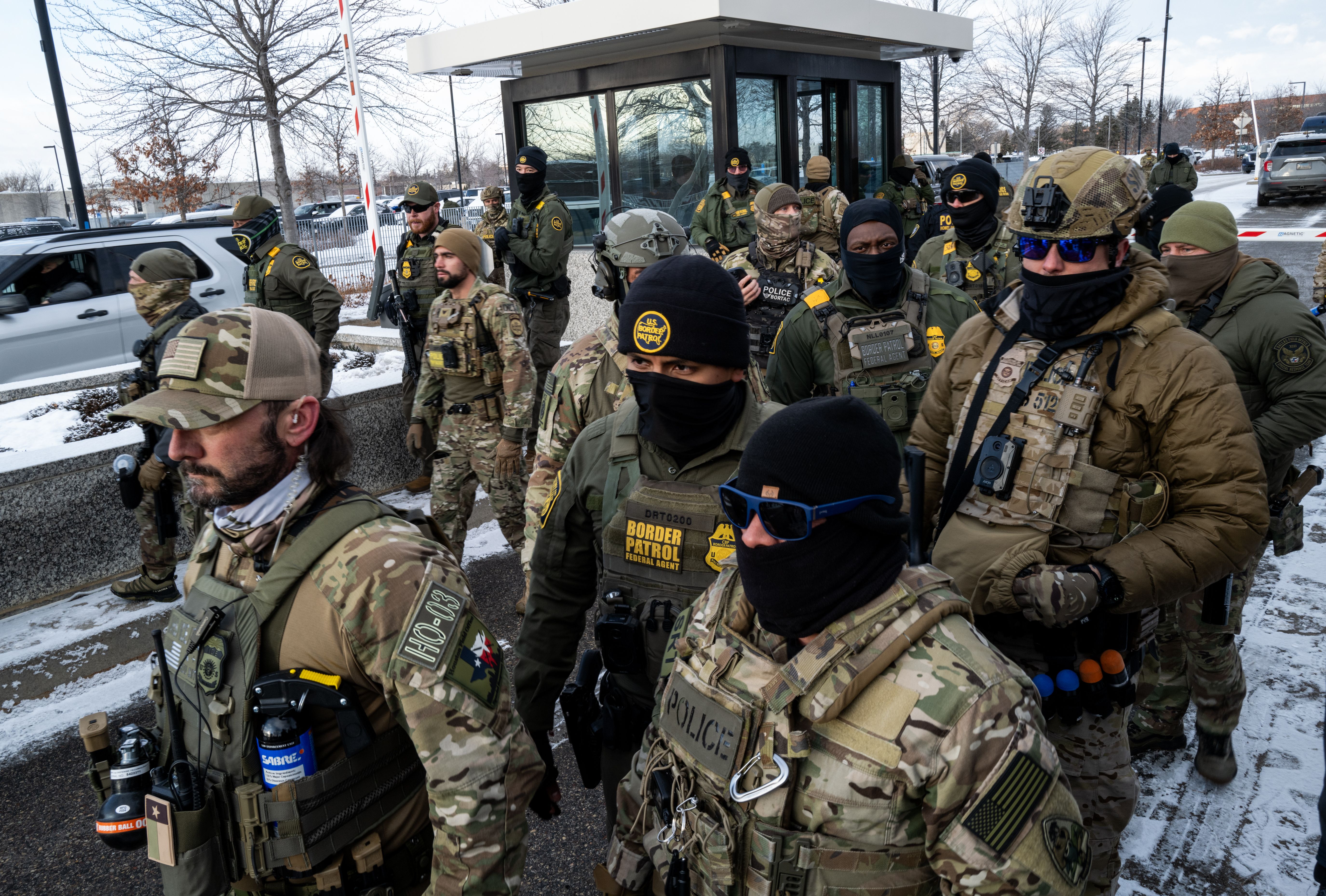 Federal agents stand at the gate of ICE's regional headquarters in Minneapolis as Reps. Ilhan Omar (D-Minn.), Kelly Morrison (D-Minn.) and Angie Craig (D-Minn.) attempt to enter. 