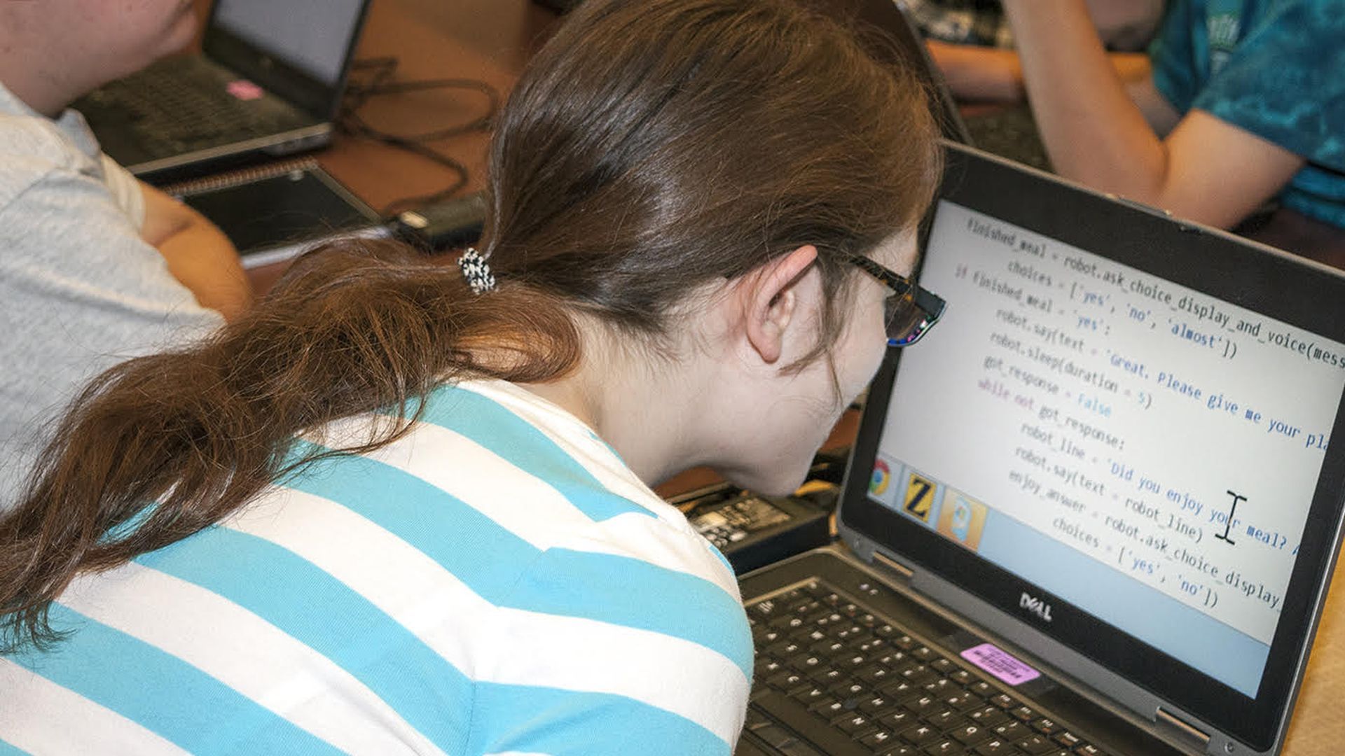 Child looking at code on a laptop