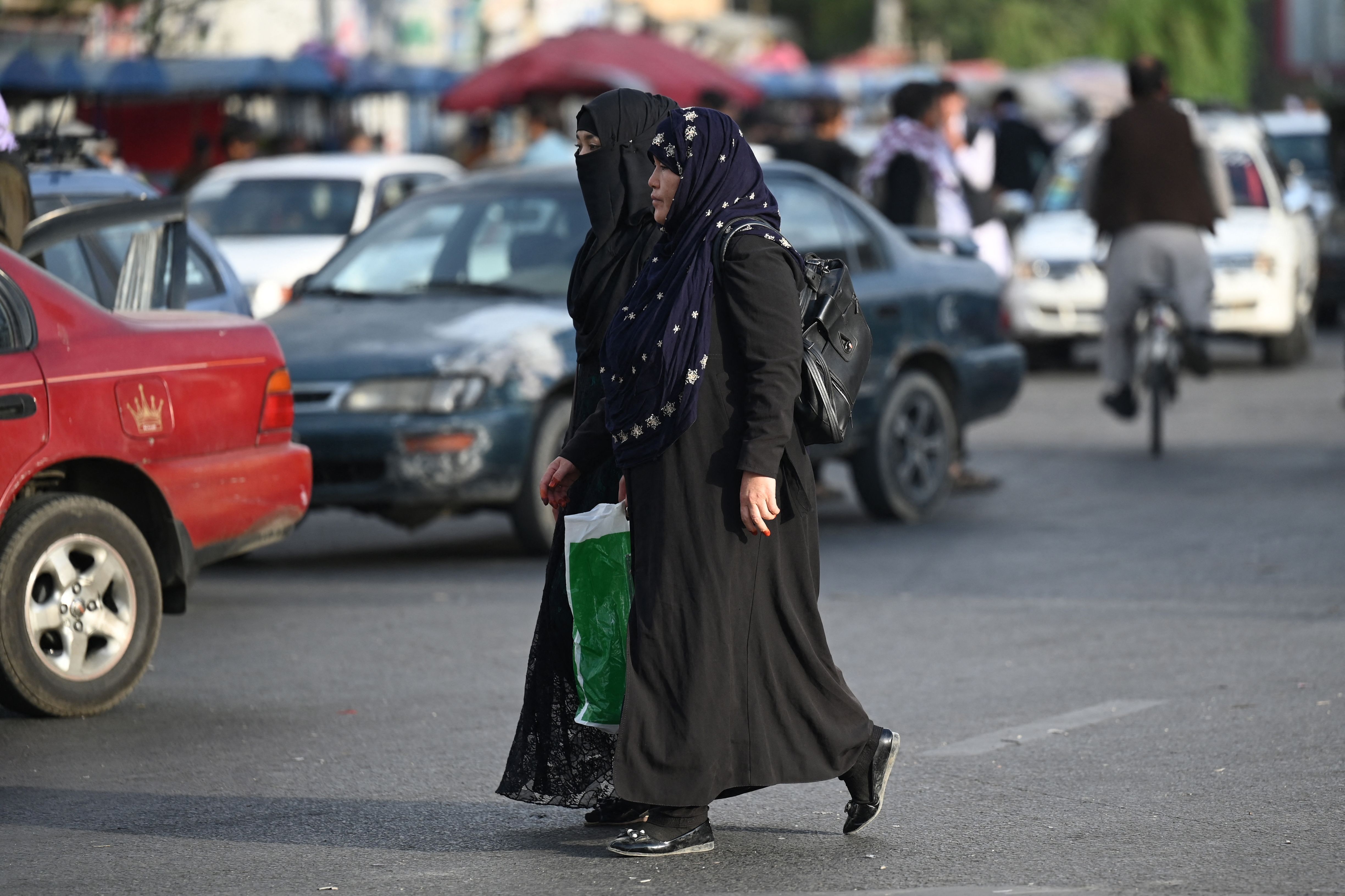  Burqa clad Afghan women cross a street in Kabul on August 31
