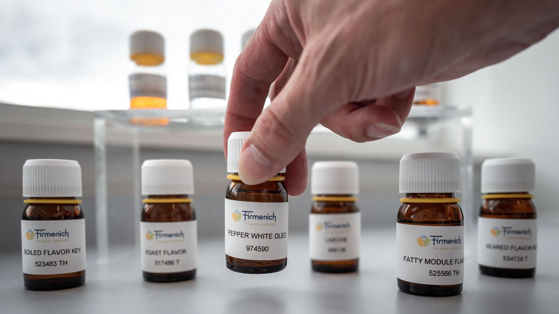 Flavourist Mark Rubin picks up a vial containing a flavour at the headquarters of Swiss group Firmenich