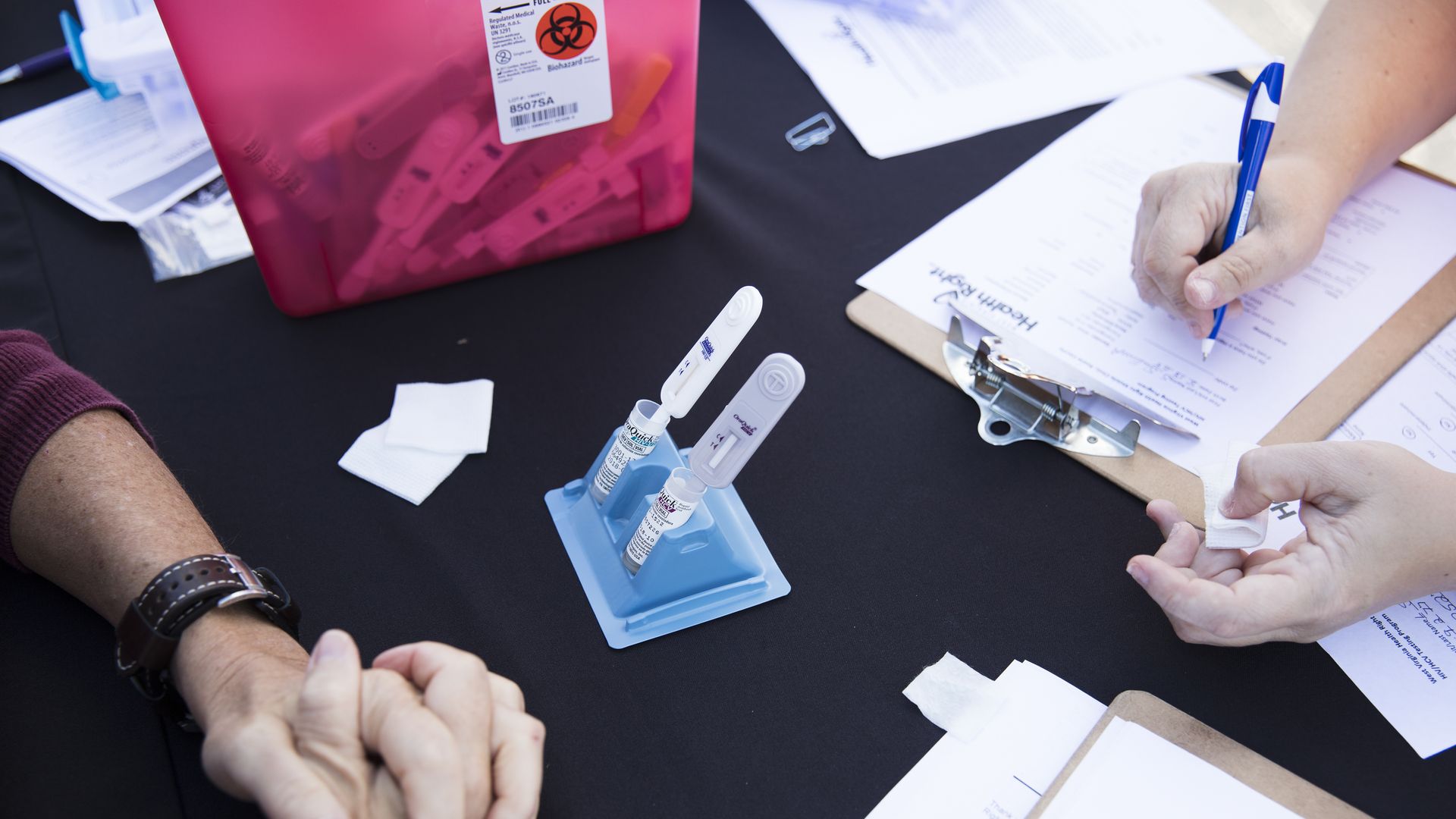 A patient fills out forms and waits to be screened for hepatitis C.