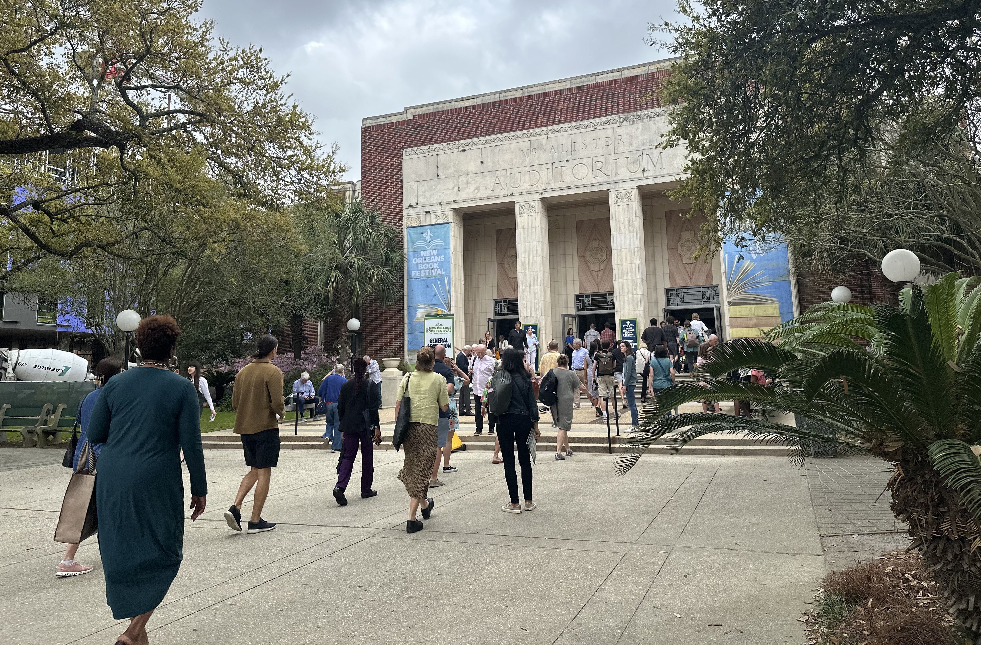People walk into and out of a building that says McAlister Auditorium. 