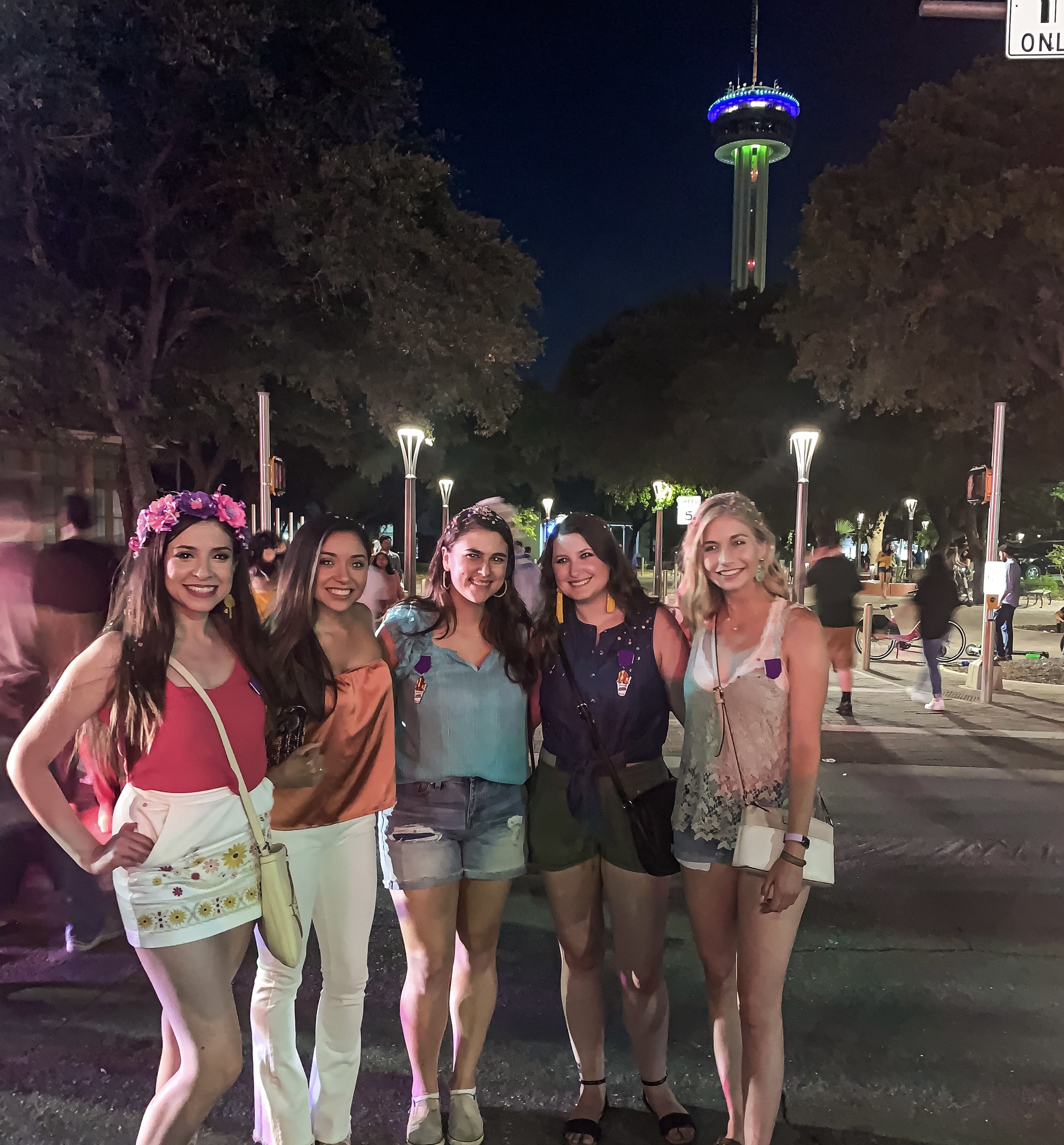 A group of five women stand together for a photo.