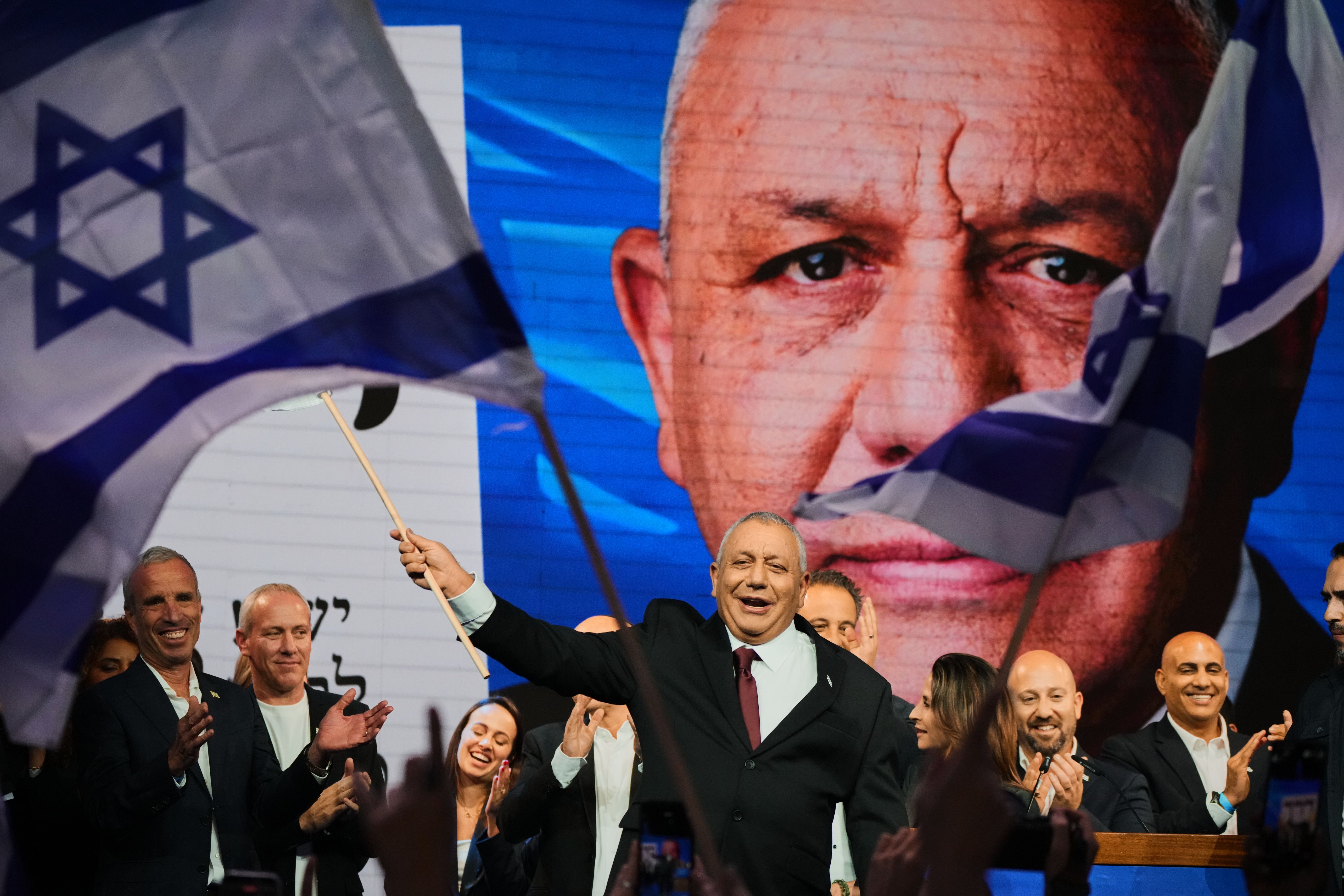 Gadi Eisenkot, leader of the Yashar party, waves an Israeli flag onstage following the release of the first exit poll in Israel's general election in Tel Aviv last night.